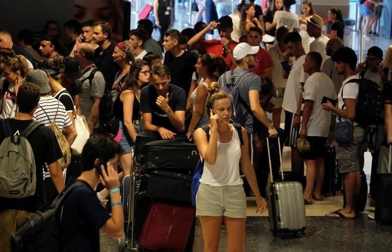 Stranded Ryanair passengers line up for information at the airport, during a protest on the first day of a cabin crew strike held in several European countries, in Valencia, Spain July 25, 2018.