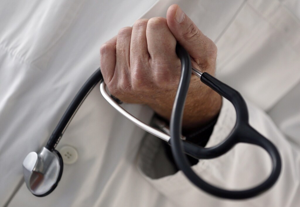 A photo illustration shows a French general practitioner holding a stethoscope in a doctor's office in Bordeaux January 7, 2015. French physicians protest against a new health reform bill that would introduce a third party payment system. Picture taken January 7, 2015. REUTERS/Regis Duvignau (FRANCE - Tags: HEALTH POLITICS) - PM1EB171G5L01