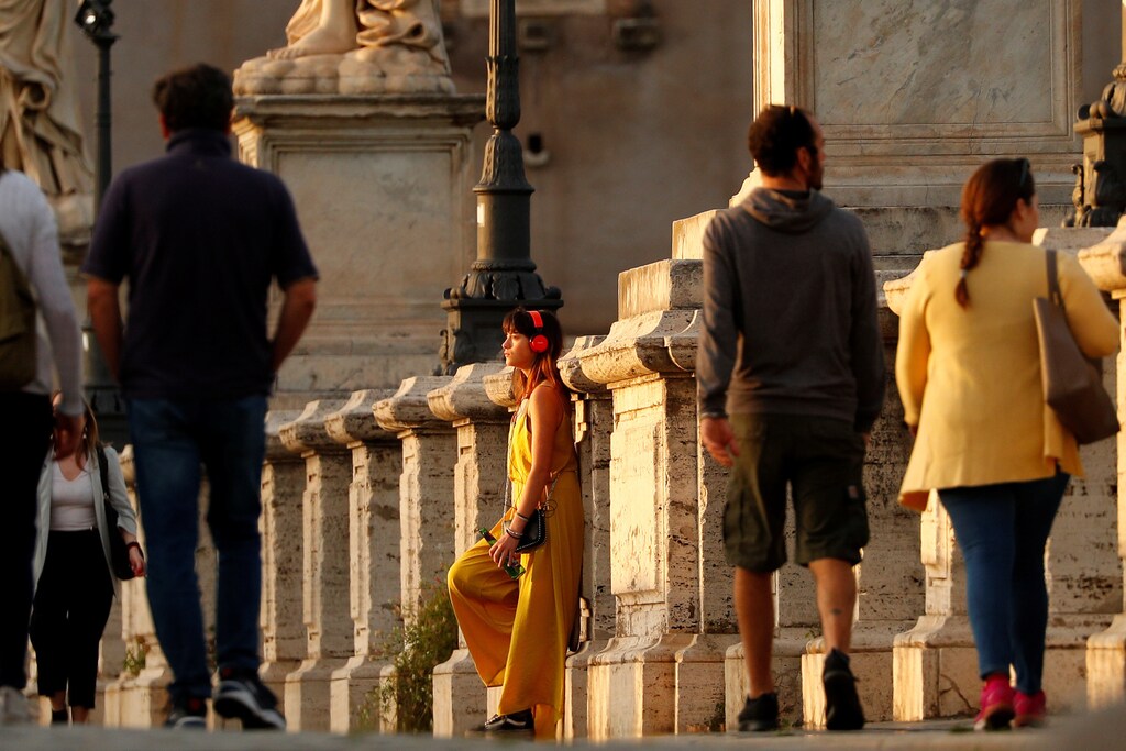 A woman wearing headphones stands on the Ponte Sant'Angelo bridge during sunset, amid the coronavirus disease (COVID-19) outbreak, in Rome, Italy, May 8, 2020. REUTERS/Guglielmo Mangiapane - RC2IKG9ZPX39