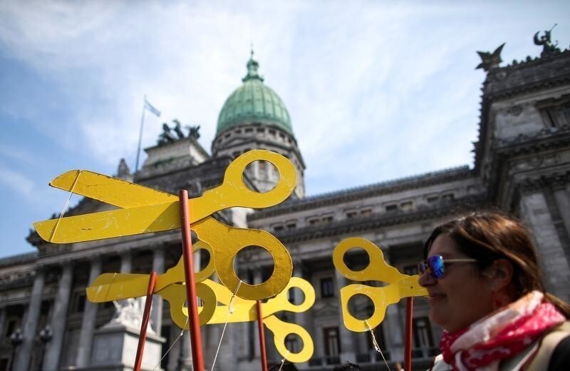 A demonstrator holds scissors cutouts during a national teachers' strike outside of the National Congress, in Buenos Aires, Argentina, September 13, 2018. REUTERS/Agustin Marcarian - RC110DB46160