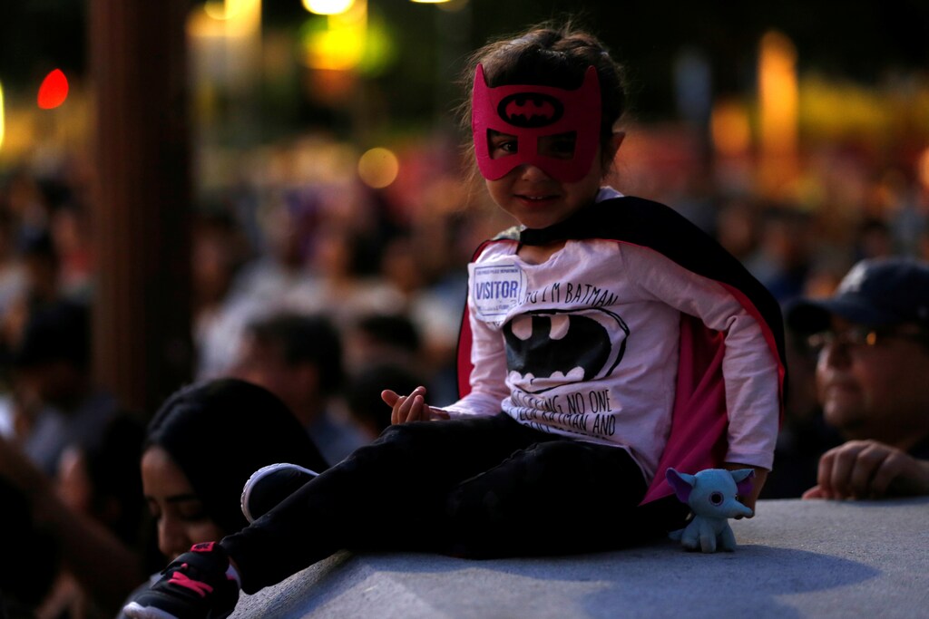 A young girl wears a costume before a bat-signal is projected on City Hall in honor of late actor Adam West in Los Angeles, California, U.S., June 15, 2017. REUTERS/Mario Anzuoni - RTS17ASM