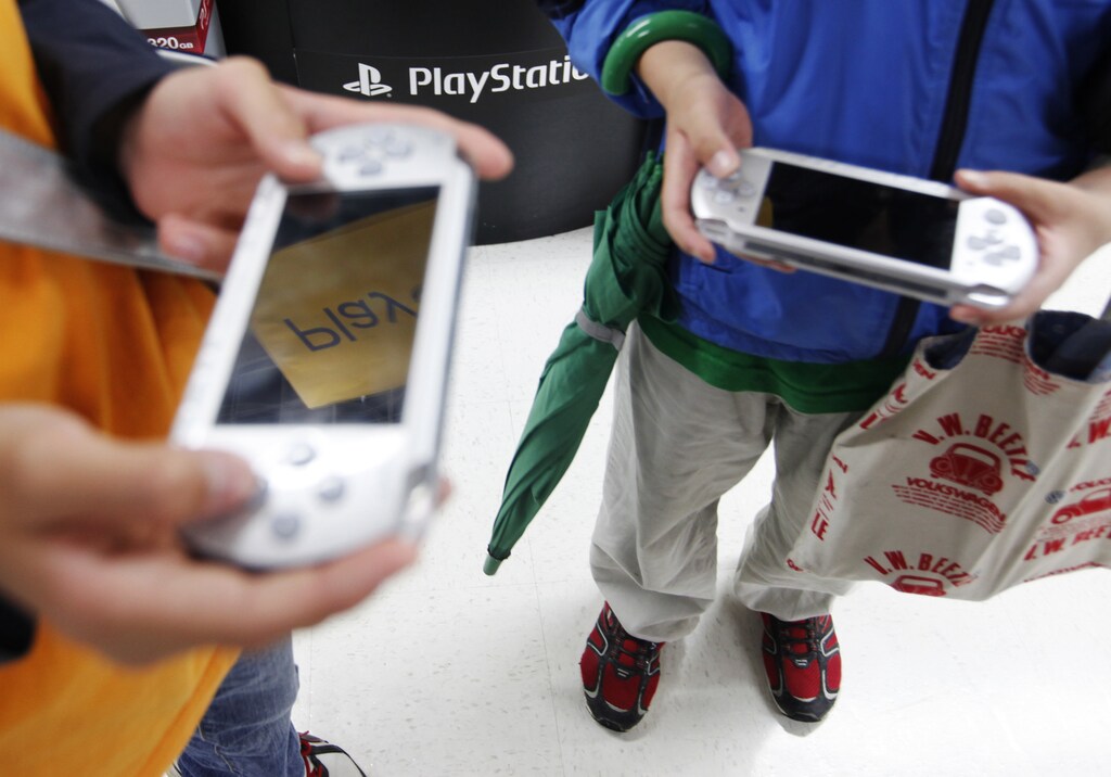 Boys play Sony Playstation Portables (PSPs) at an electronic shop in Tokyo May 7, 2011. Sony said on Saturday it had removed from the Internet the names and partial addresses of 2,500 sweepstakes contestants that had been stolen by hackers and posted on a website, and said it did not know when it could restart its PlayStation video games network. REUTERS/Kim Kyung-Hoon (JAPAN - Tags: CRIME LAW SCI TECH BUSINESS) - GM1E7571CAW01