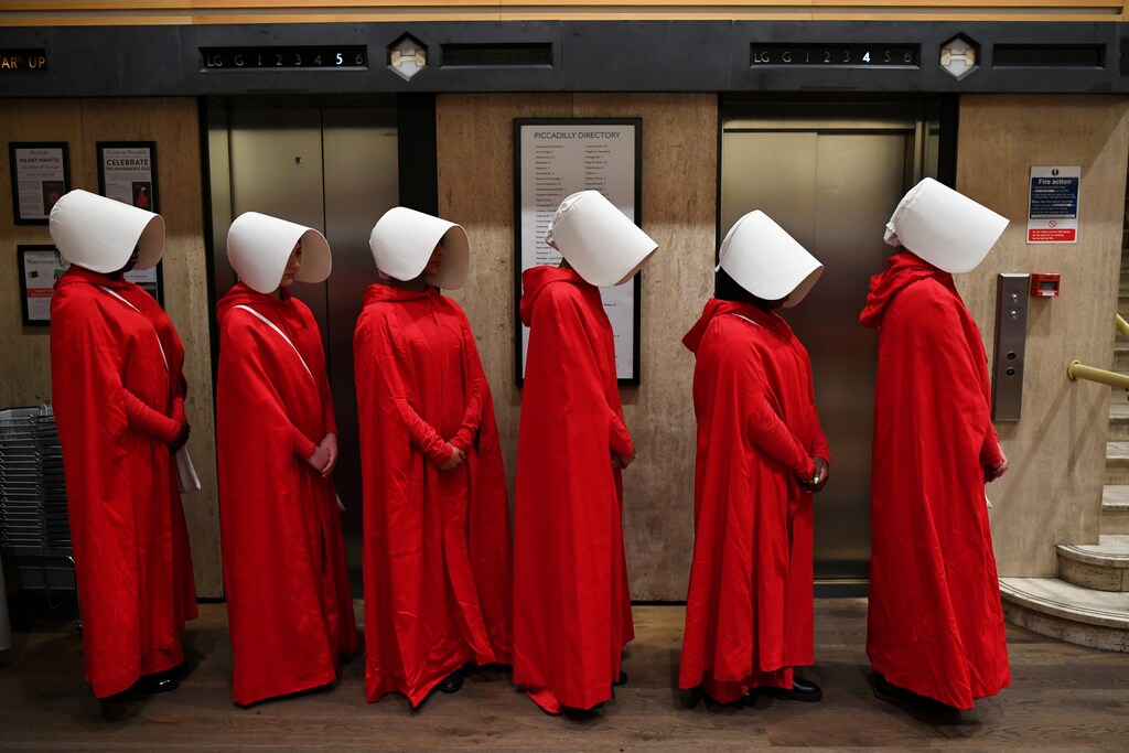 People dressed up as characters from Margaret Atwood's "The Handmaid's Tale" queue to get a copy of her new novel "The Testaments" at Waterstones bookshop in London, Britain, September 9, 2019. REUTERS/Dylan Martinez TPX IMAGES OF THE DAY - RC1A917F7F90