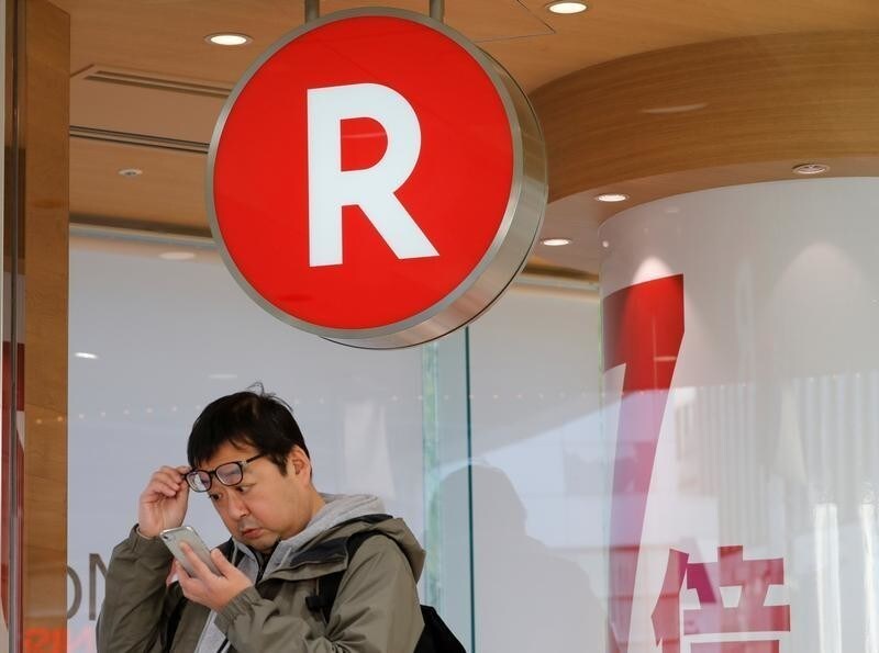 A man uses a mobile phone in front of a Rakuten Mobile branch in Tokyo, Japan December 14, 2017. REUTERS/Kim Kyung-Hoon - RC18420BBA90