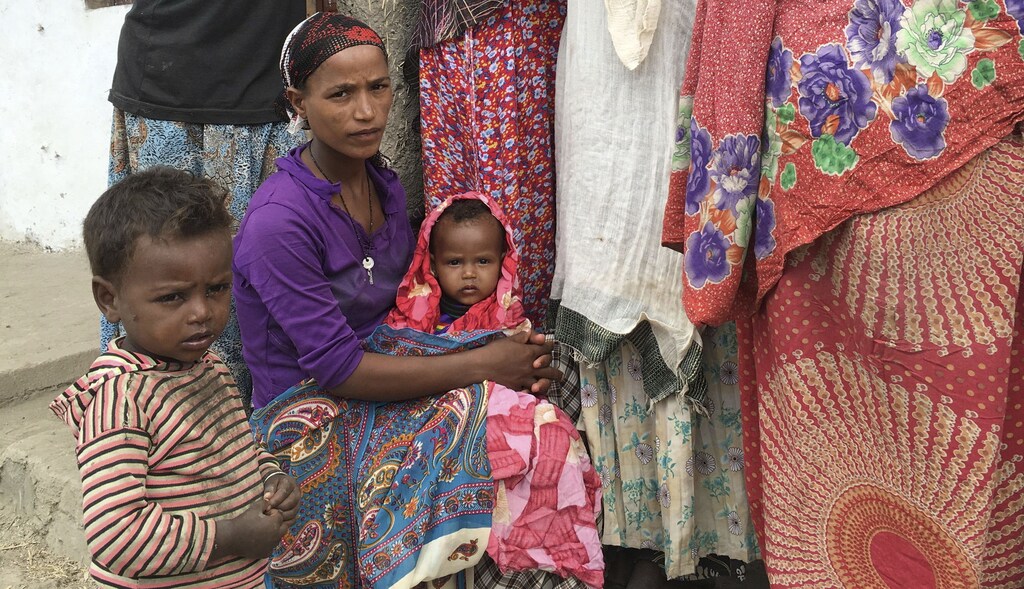 A woman holds her child as she awaits medical attention at the Halo health post in Halo village, a drought-stricken area in Oromia region in Ethiopia, January 31, 2016. Picture taken January 31, 2016. REUTERS/Edmund Blair - RTX24V3Y