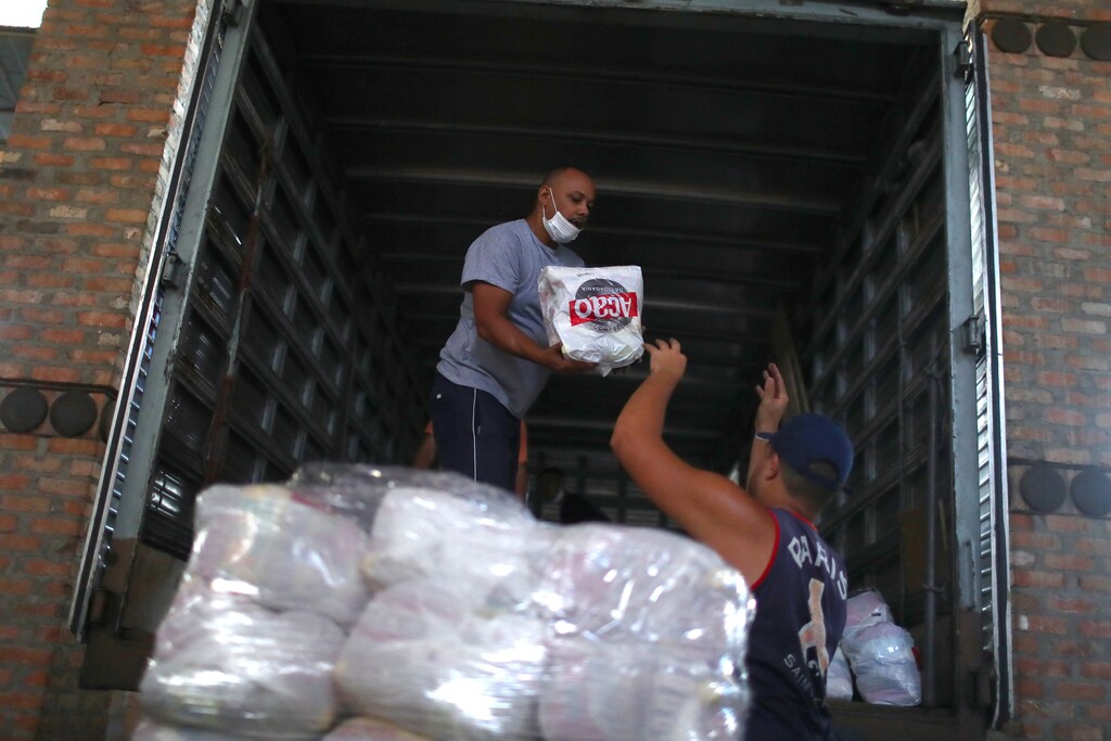 Workers upload a truck with donated aid for poor families of the Rocinha slum as the coronavirus disease (COVID-19) outbreak continues, at the Acao da Cidadania NGO headquarter in Rio de Janeiro, Brazil March 27, 2020. REUTERS/Pilar Olivares - RC2HSF9GQ3R1