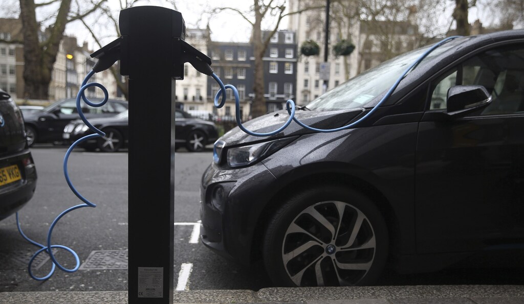 Electric cars are plugged into a charging point in London, Britain April 7, 2016.