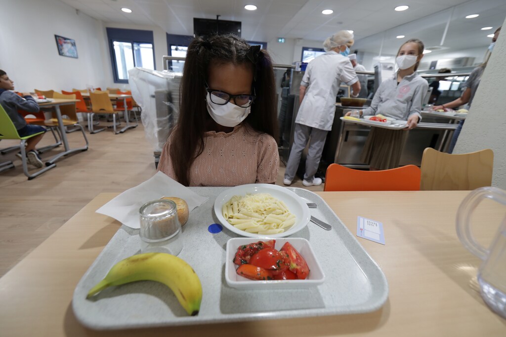 A secondary school student, wearing a protective face mask, sits in front of her meal tray in the school canteen room at the College Henri Matisse school during its reopening in Nice as French children return to their schools after the summer break with protective face masks and social distancing as part of efforts to curb a resurgence of the coronavirus disease (COVID-19) across France, September 1, 2020. REUTERS/Eric Gaillard - RC2MPI920XA0