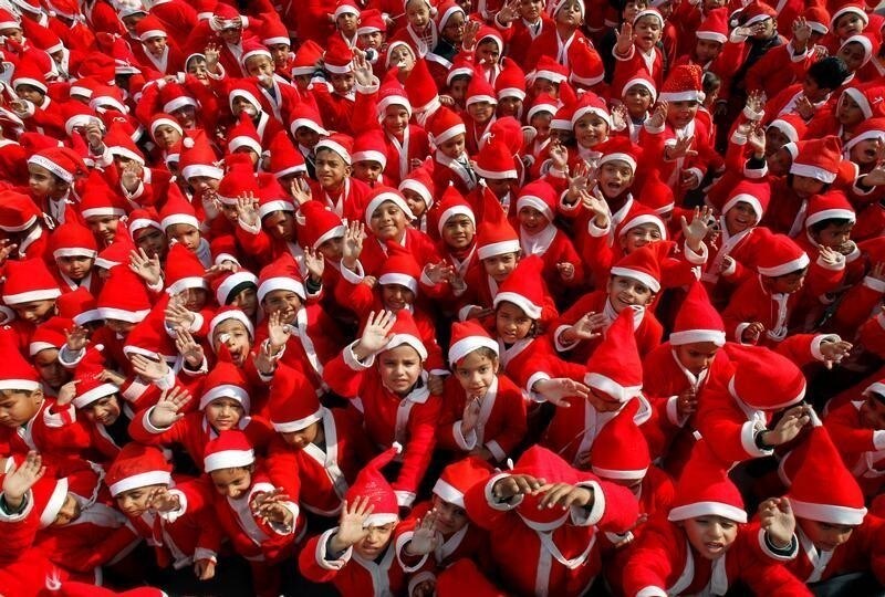 Children dressed in Santa Claus costumes wave as they participate in Christmas celebrations at a school in Chandigarh, India, December 20, 2017. REUTERS/Ajay Verma - RC131068DD60