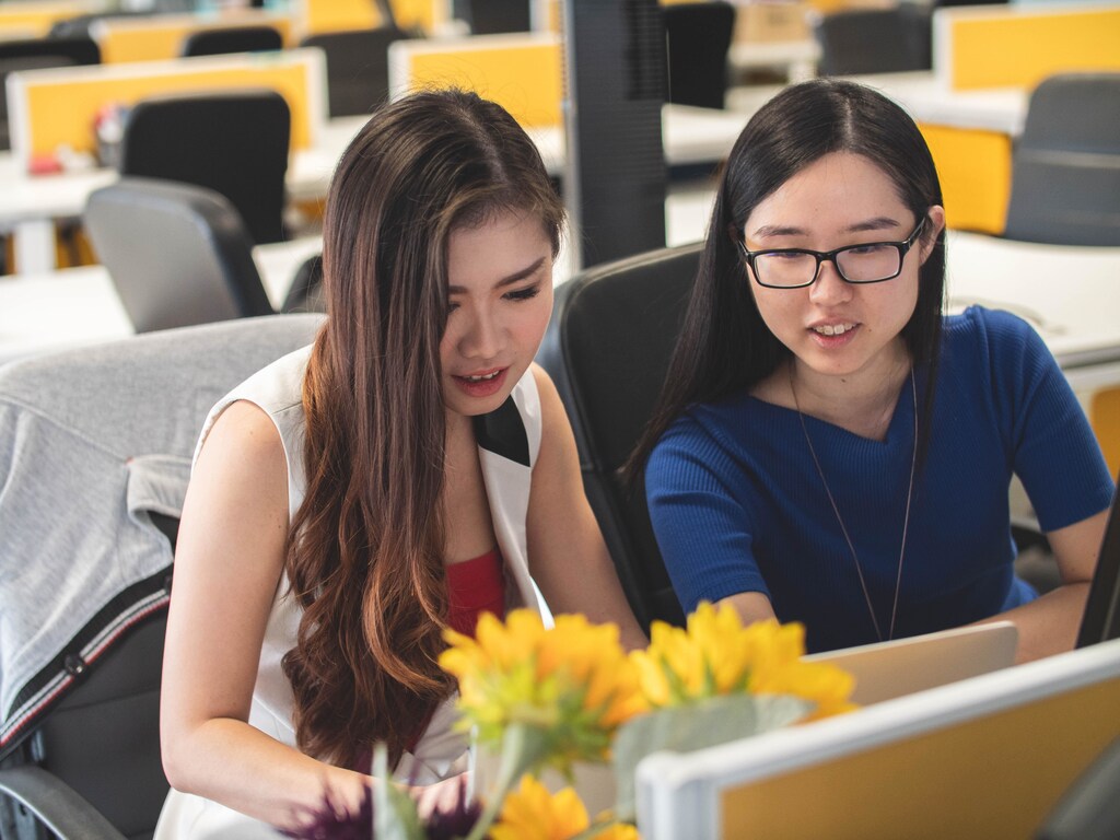 How can we improve Gen Z employment opportunities? Pictured: Two Gen Z employees look at a laptop