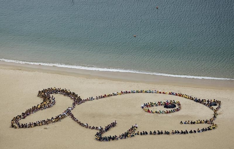 Hundreds of school children, teachers and volunteers form the shape of a fish with a sad expression at Repulse Bay in Hong Kong April 23, 2015. The event was in honor of Kids Ocean Day, to send a global message to stop consuming reef fish in order to protect the earth's coral reefs, according to the organiser. The image was originally drawn by a local seven-year-old student. REUTERS/Bobby Yip - GF10000069530