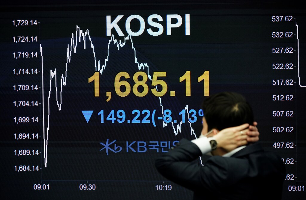 A currency dealer works in front of an electronic board showing the Korea Composite Stock Price Index (KOSPI) at a dealing room of a bank in Seoul, South Korea, March 13, 2020. REUTERS/Kim Hong-Ji - RC2QIF9NGH47