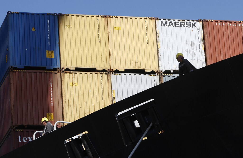 Crew members of a ship loaded with containers filled with rubbish from Britain wait for its departure from the port of Santos August 5, 2009. The ship loaded with 1,600 tonnes of rubbish set sail today to return the rotting cargo to Britain from Brazil, where it had been shipped falsely declared as plastic for recycling. REUTERS/Paulo Whitaker