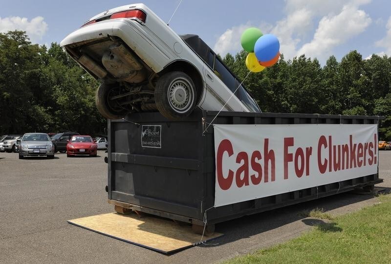 An old car dropped in an industrial trash bin advertising the Cash for Clunkers program at Battlefield Ford in Culpeper, Virginia, August 1, 2009. Americans flocked to auto dealerships this month to take advantage of government rebates for gas-guzzling "clunkers" and promptly drained the program's $1 billion in funding, leaving some prospective buyers in limbo. REUTERS/Jonathan Ernst (UNITED STATES TRANSPORT POLITICS BUSINESS IMAGES OF THE DAY) - GM1E5820AR701