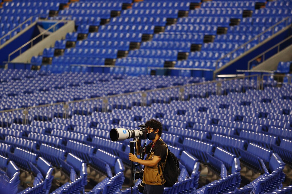 Tokyo 2020 Olympics - Softball - Women - Finals - Gold Medal Game - Japan v United States - Yokohama Baseball Stadium - Yokohama, Japan - July 27, 2021. A lone photographer works between empty seats in the stands as paying spectators are not allowed due to the coronavirus disease (COVID-19) pandemic. REUTERS/Jorge Silva - SP1EH7R0ZCXH7