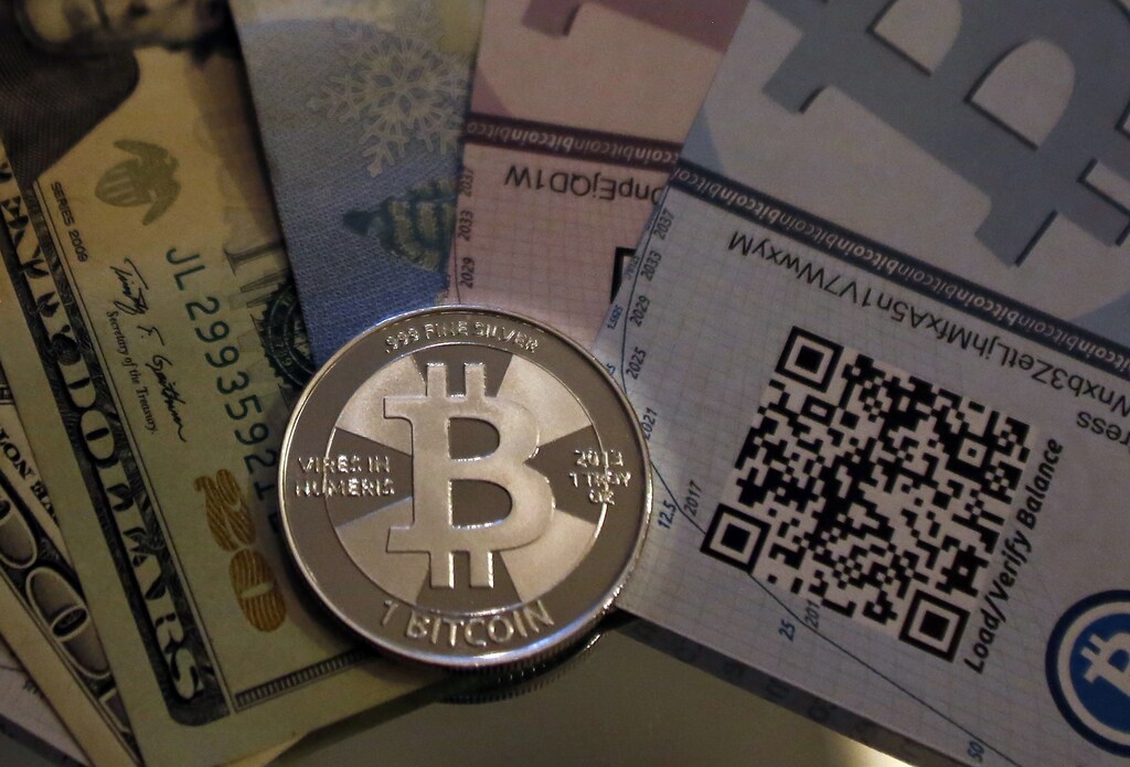 One of Bitcoin enthusiast Mike Caldwell's coins in this photo illustration at his office in Sandy, Utah, September 17, 2013. Bitcoins, touted by some experts as the future of money, gained in prominence during Europe's financial crisis as more people questioned the safety of holding their cash in the bank. Cameron and Tyler Winklevoss, currently making headlines with plans to launch a Bitcoin fund, said on Tuesday that they could see the digital currency becoming a country's official money. REUTERS/Jim Urquhart (UNITED STATES - Tags: BUSINESS SOCIETY) - GM1E99J0AHG01