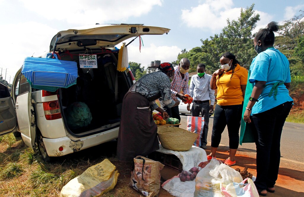 Motorists sell fruits and vegetables to customers next to their vehicle, used as an alternative mobile grocery stall, along the highway, following a lockdown due to the coronavirus disease (COVID-19) outbreak, on the outskirts of Nairobi, Kenya May 25, 2020. REUTERS/Njeri Mwangi - RC2OVG9SG2UP