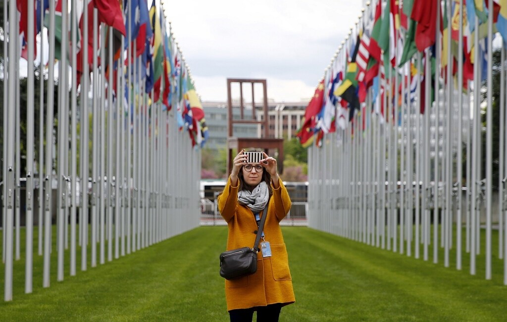 A staff takes a selfie in the flags alley at the European headquarters of the United Nations in Geneva, Switzerland, April 26, 2016. REUTERS/Denis Balibouse - GF10000396206