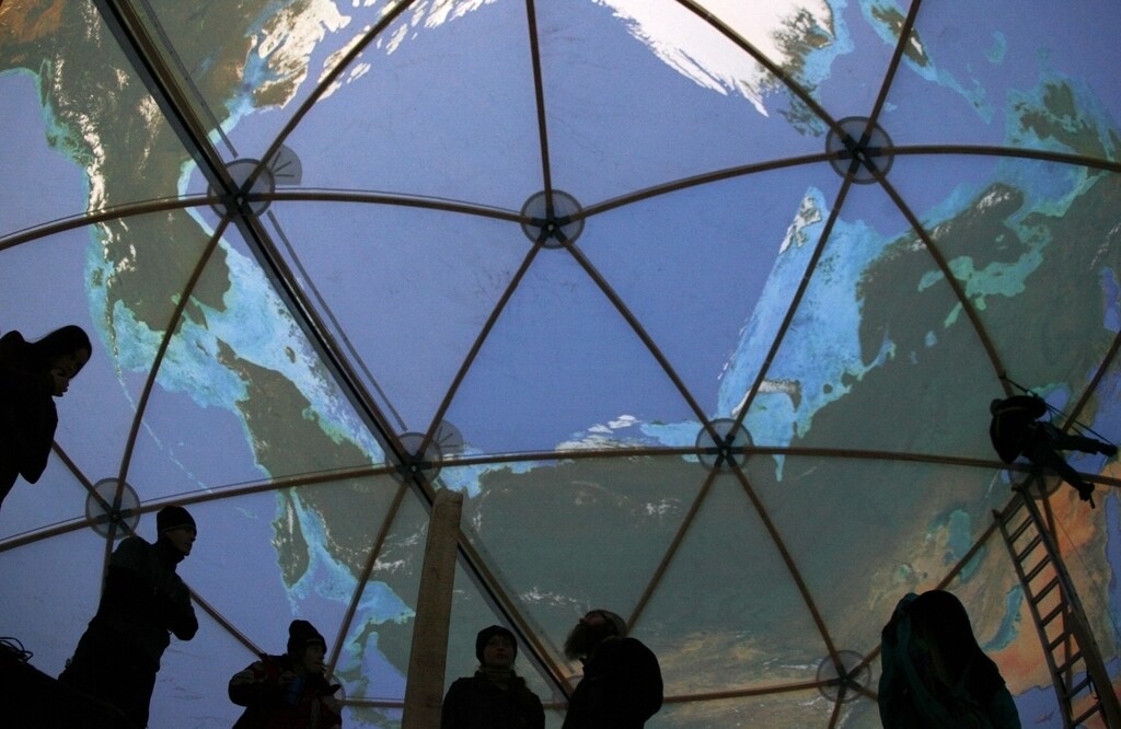 Greenpeace activists stand inside a giant model of the globe near Konin open mine, 70 km from Poznan, western Poland December 3, 2008. Greenpeace established a camp to protest against the damage it says the Konin mine is doing to the climate, regional tourism and farming, and against the planned opening of new sites. REUTERS/Kacper Pempel (POLAND) - GM1E4C406F601