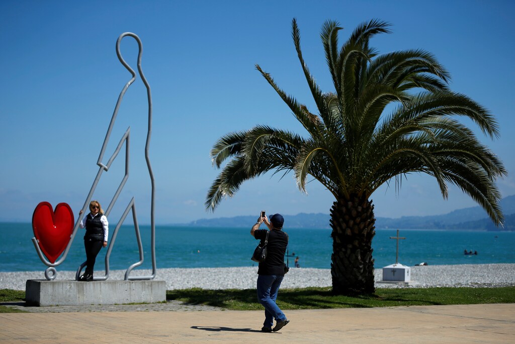 Tourists take photos at a seaside boulevard in Batumi, Georgia, May 2, 2016. REUTERS/David Mdzinarishvili - D1AETCHMWQAD