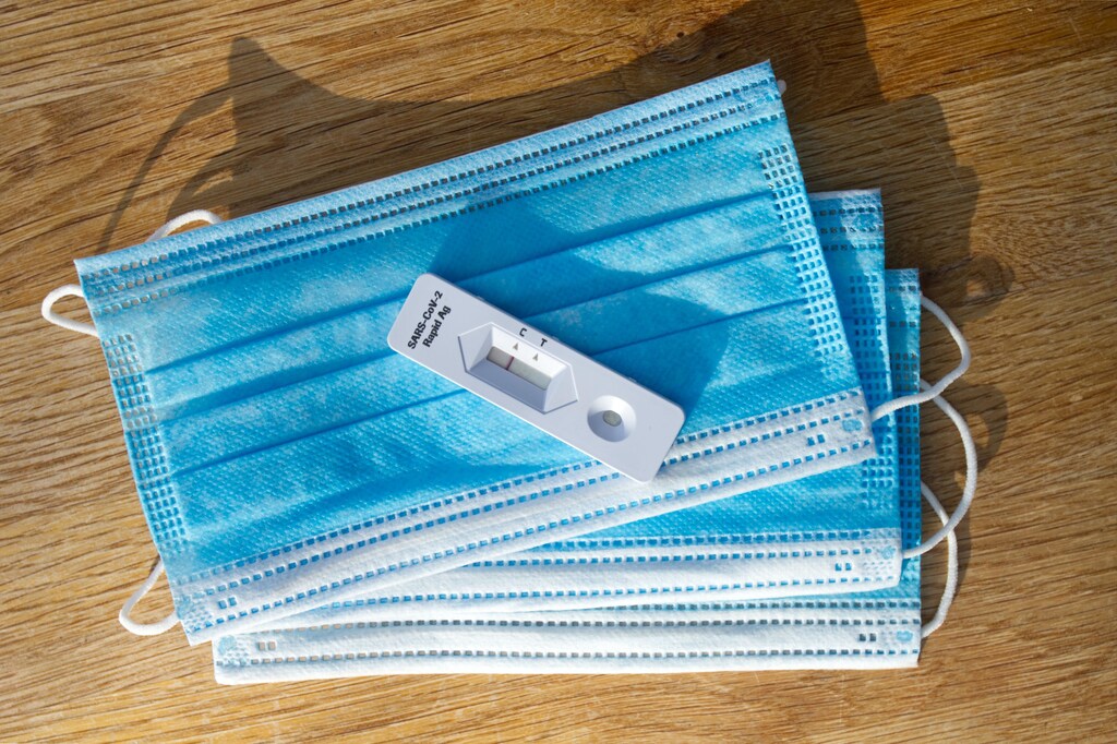 A rapid COVID-19 test on top of a pile of face masks.
