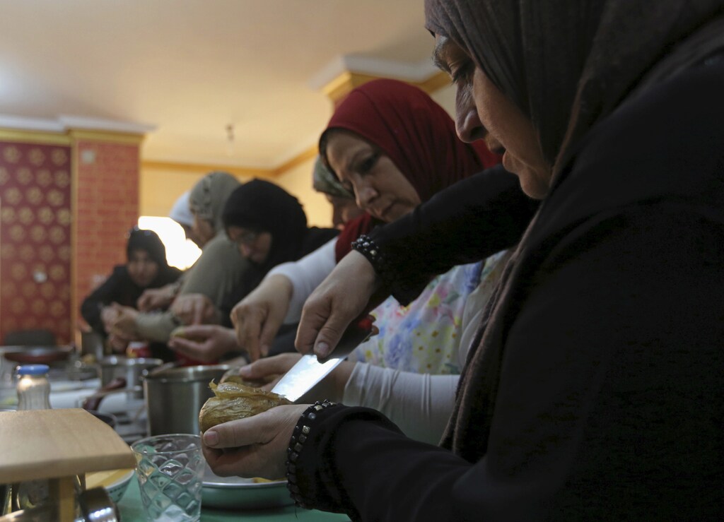 Syrian, Iraqi and Sudanese refugees attend a cooking class in Cairo.