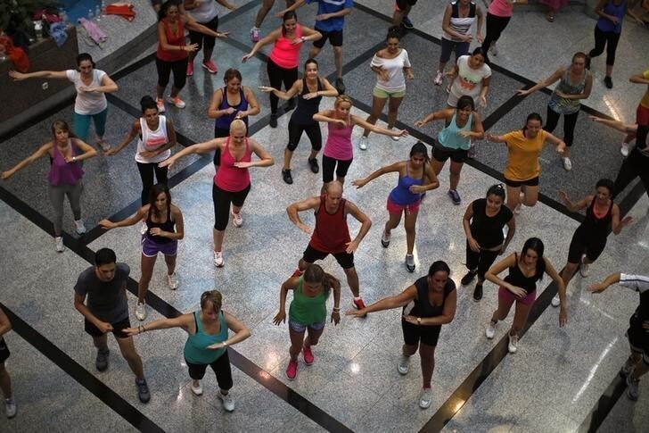 People take part in an aerobics class at a shopping centre in Malaga, southern Spain, August 1, 2014. Picture taken August 1, 2014. REUTERS/Jon Nazca (SPAIN - Tags: HEALTH SOCIETY)