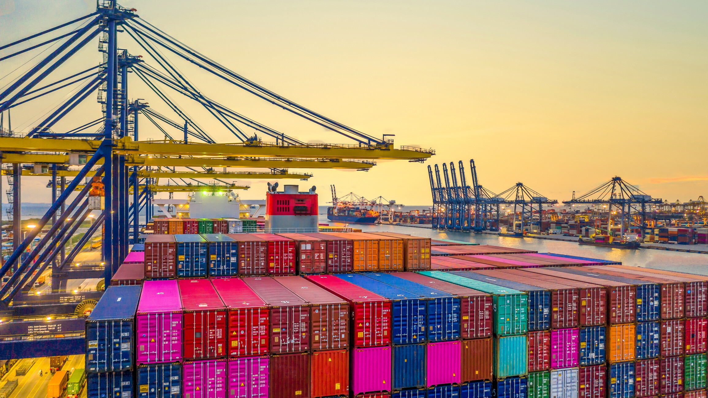 Container ship working at night, Business import export logistic and transportation of International by container ship in the open sea, Aerial view industrial crane loading cargo freight seaport. Global trade