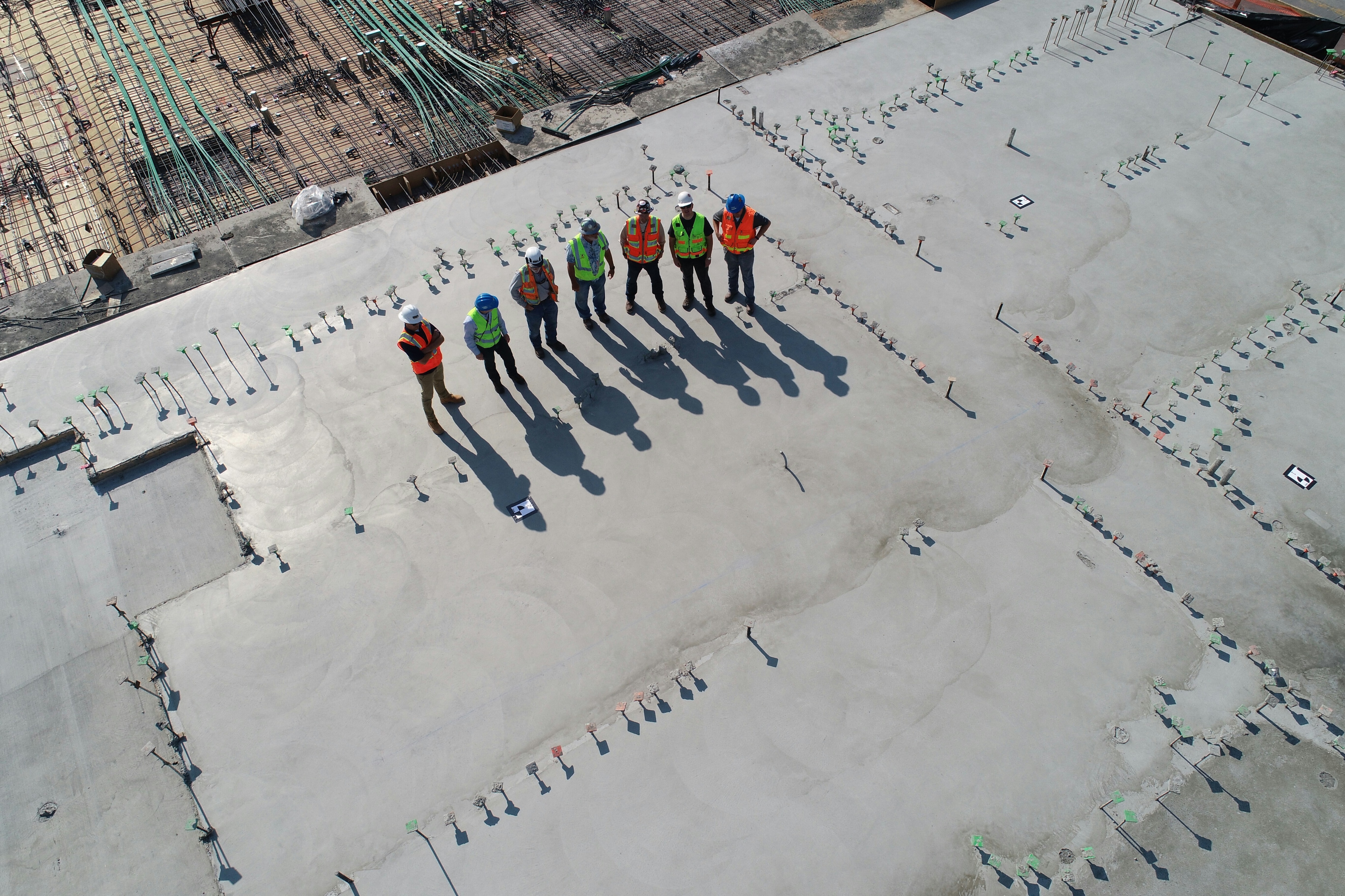 seven construction workers standing on white field; critical infastructure, data centre