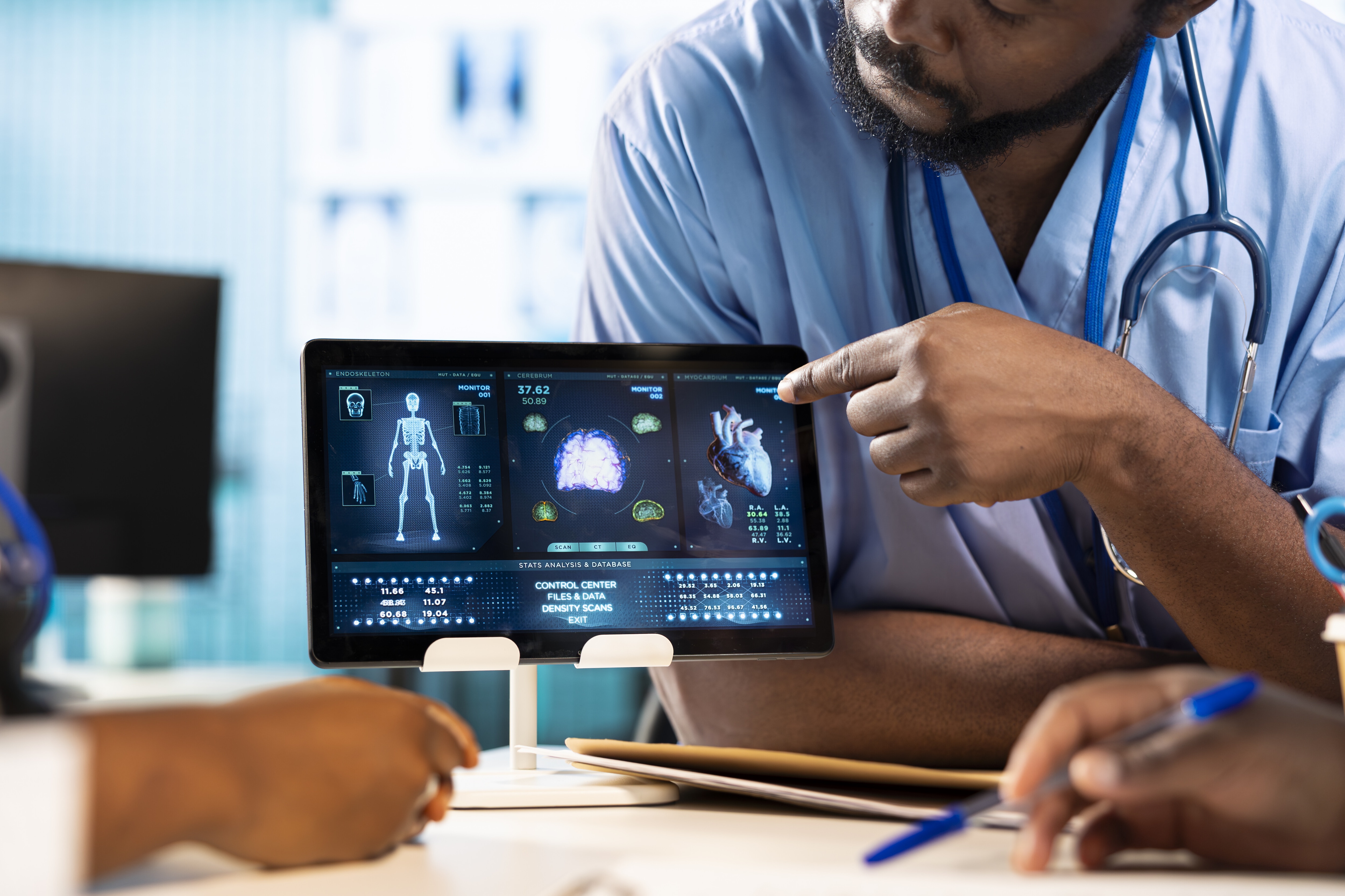 Close-up of a medic's hand pointing at a tablet screen. AI can help train healthcare staff to address shortages