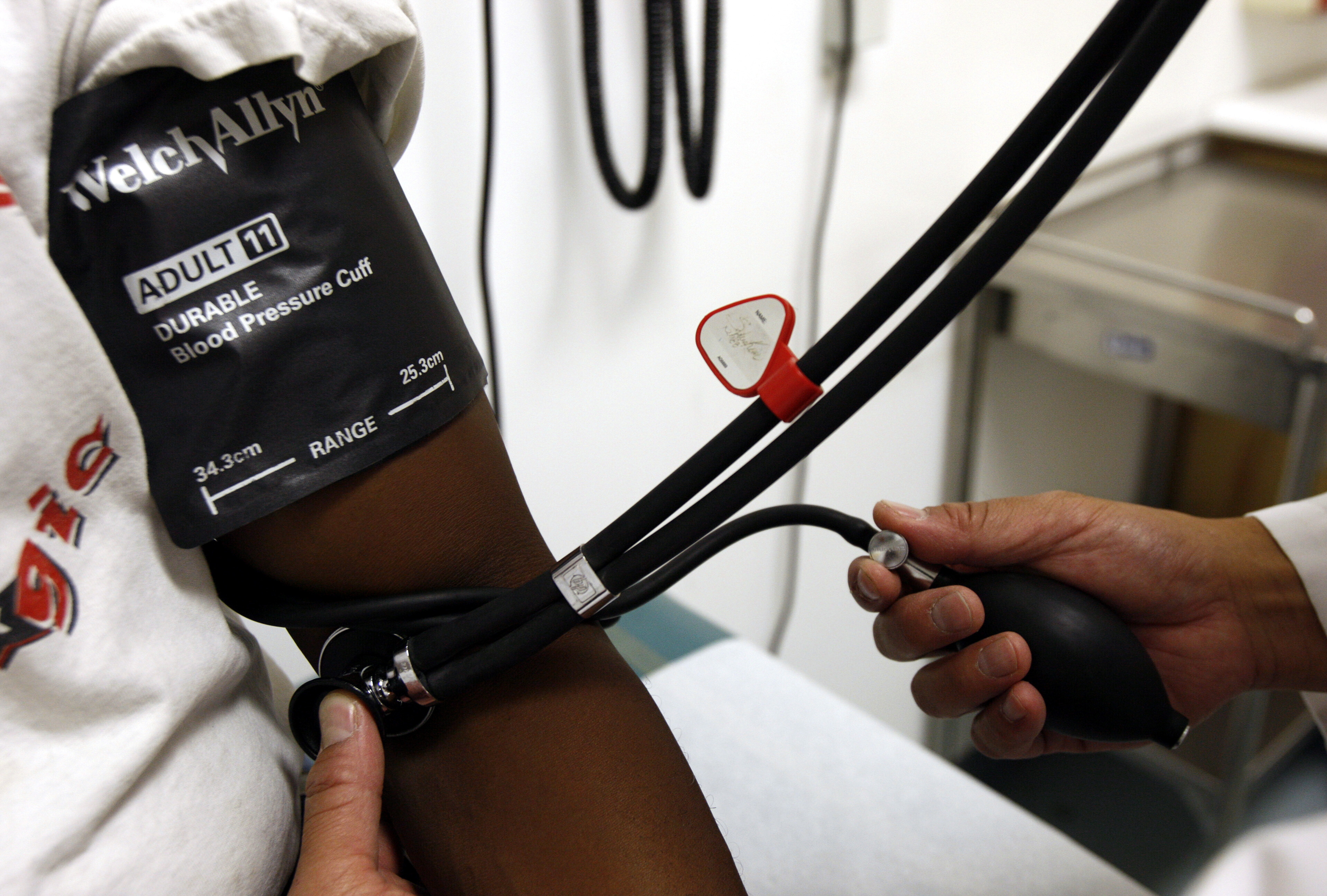 A doctor checks the blood pressure of a patient at the J.W.C.H. safety-net clinic in the center of skid row in downtown Los Angeles July 30, 2007. REUTERS/Lucy Nicholson (UNITED STATES)