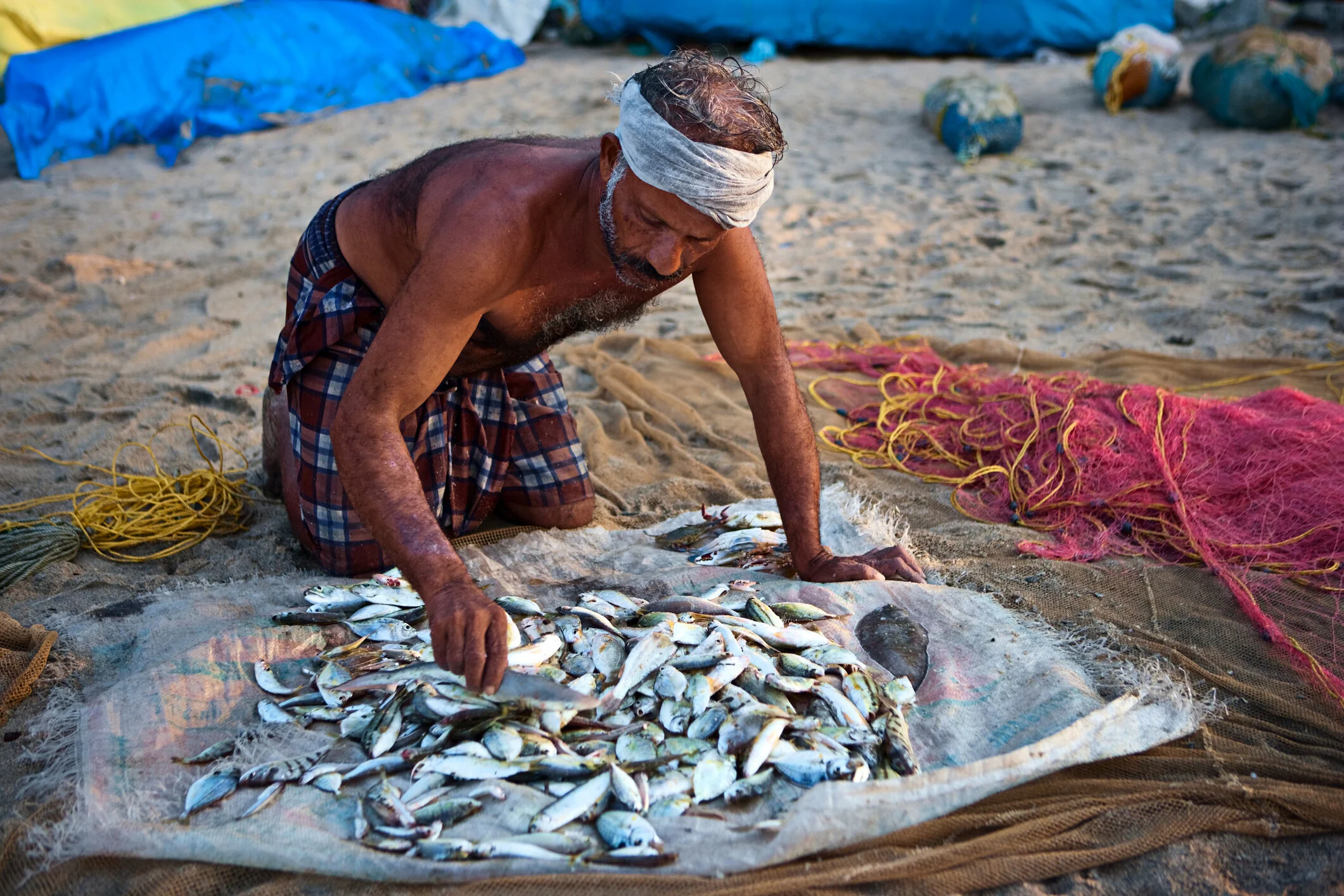 Pescador indio en el trabajo, Kerala, India. Contaminación del aire, trabajadores mayores, economía de longevidad, fuerza laboral envejecida.