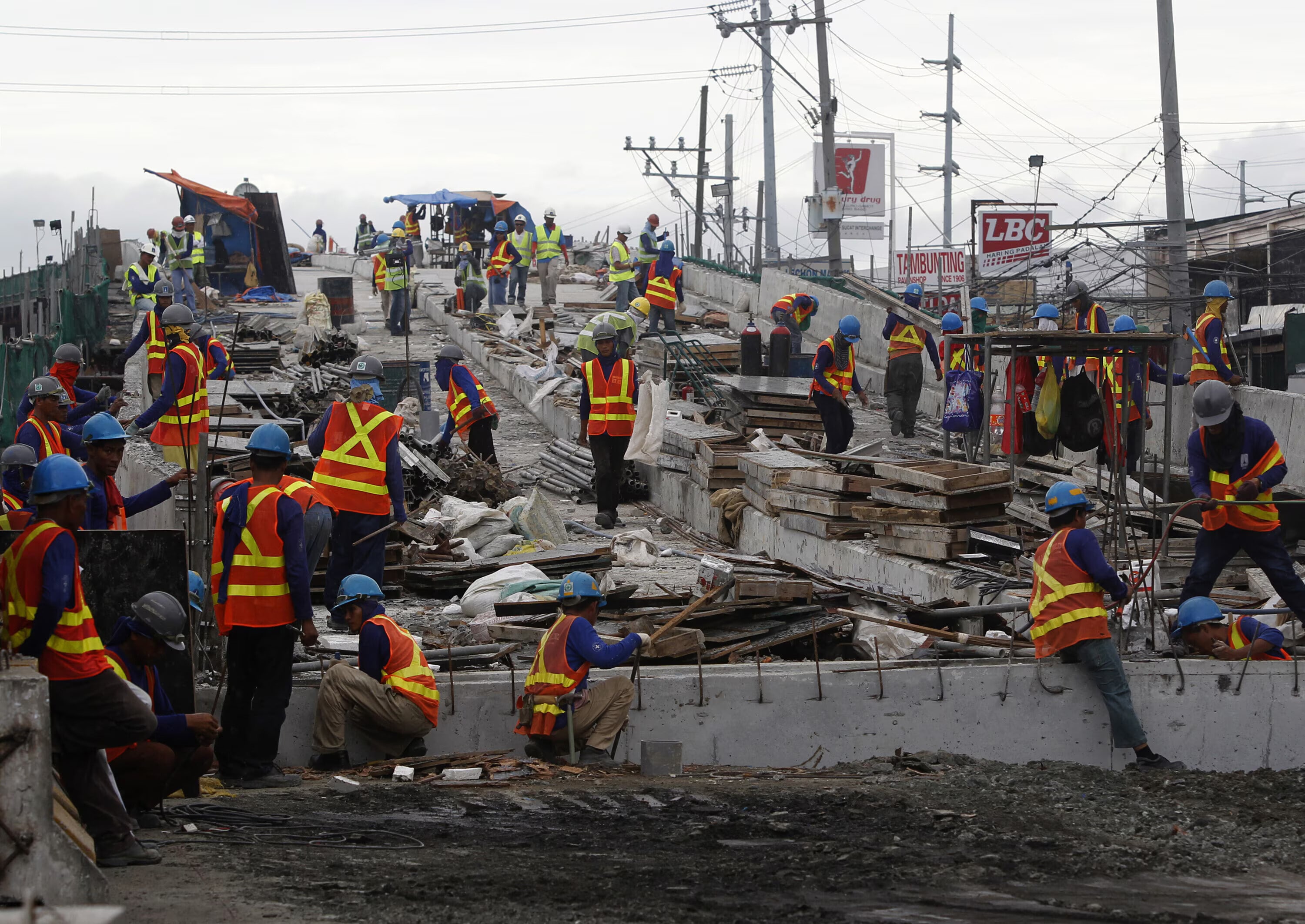 2010年11月15日、フィリピン、マニラ近郊のパラニャーケ市の南高速道路沿いで、フィリピン人労働者が「スカイウェイ」の建設に従事する様子。トークン化は、インフラ投資の参入障壁を低減します。