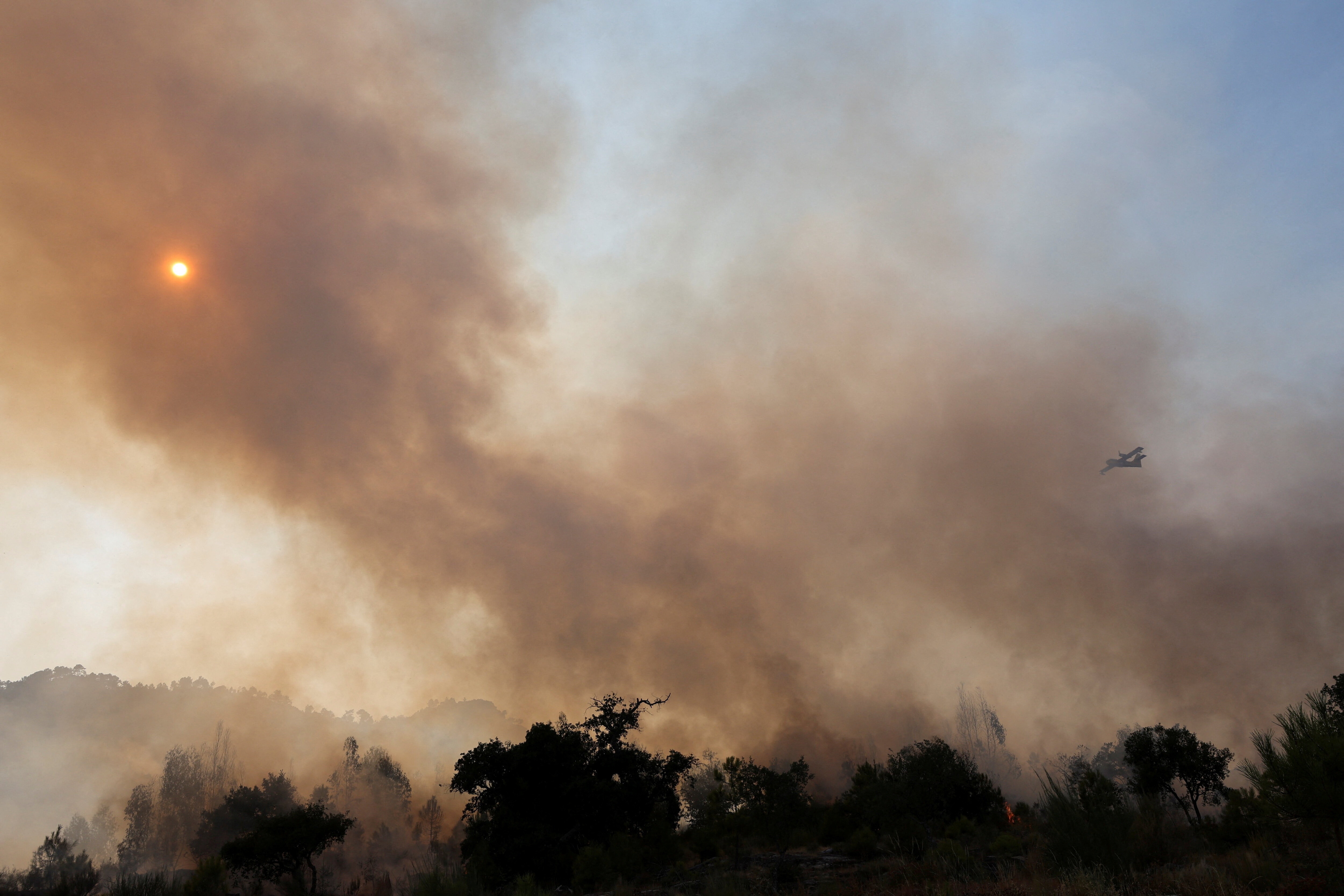 A firefighting aeroplane flies over a wildfire in Castelo Novo, Fundao area, Portugal.