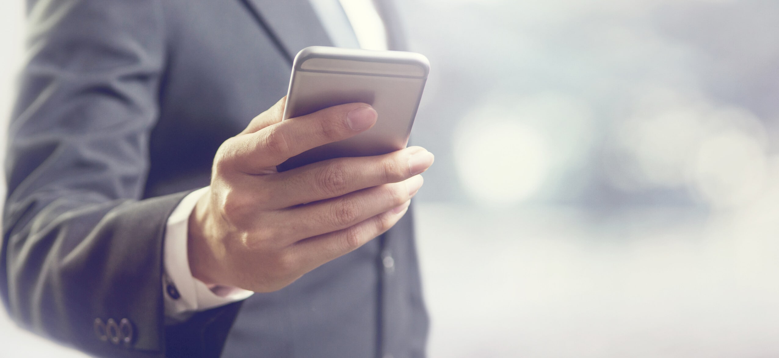 Close up of a business man using mobile smart phone, copy space. Future of finance