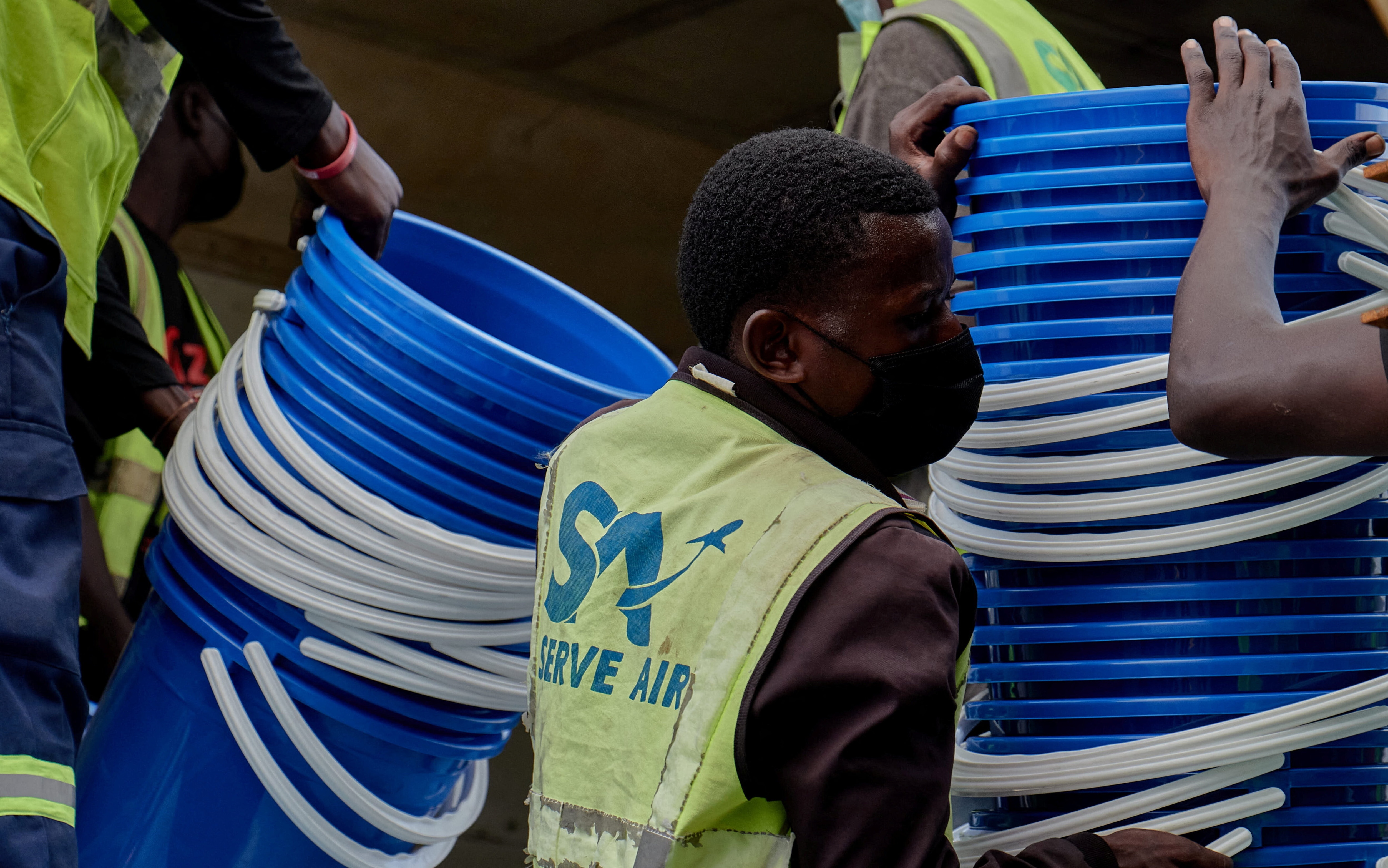 Airport workers receive an aircraft loaded with medical supplies and emergency kits as aid agencies work to contain a new Ebola outbreak involving the Bundibugyo strain, at the Bunia National Airport in Bunia, Ituri province, Democratic Republic of Congo, May 19, 2026.