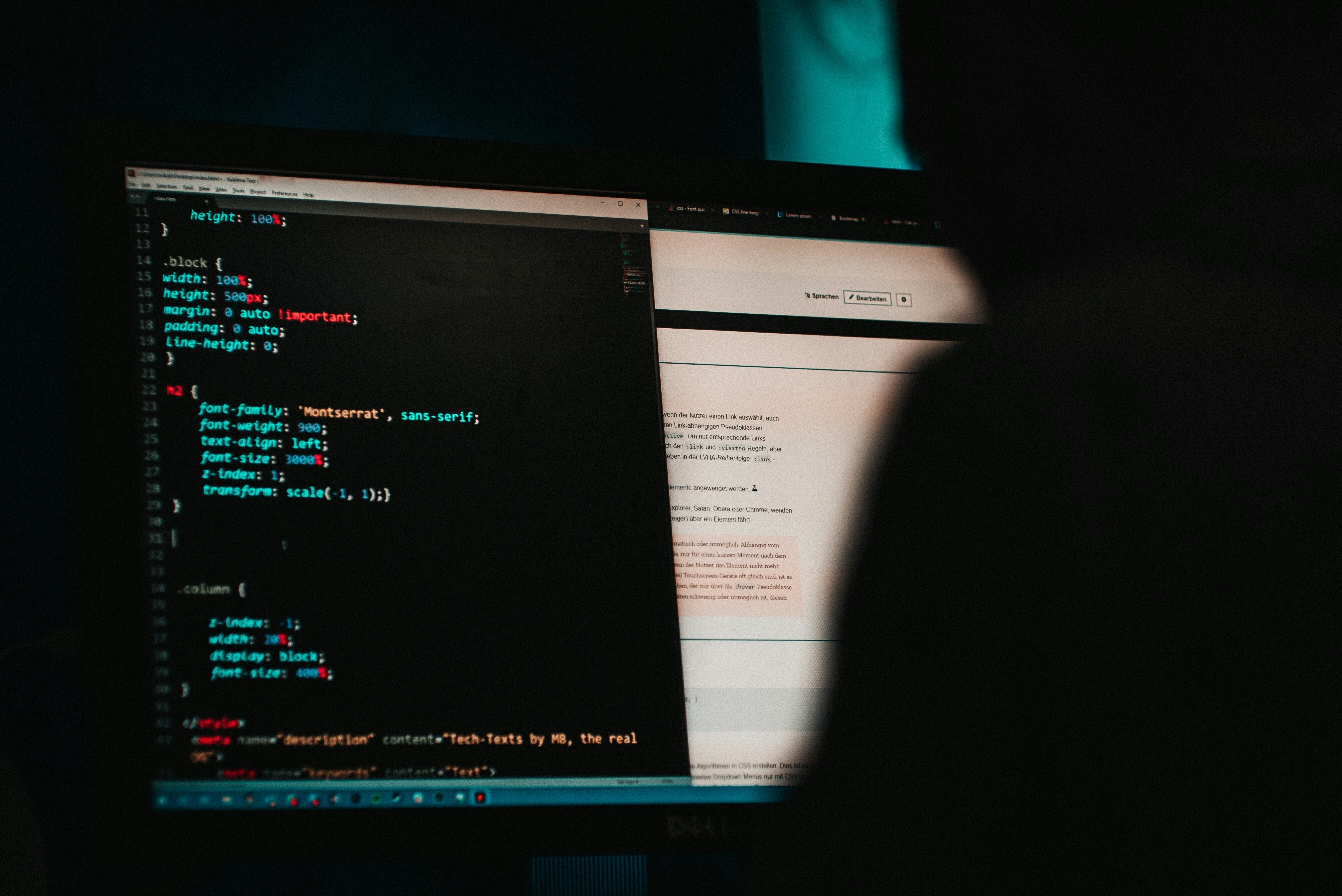 A coder works at a computer in a dark room.