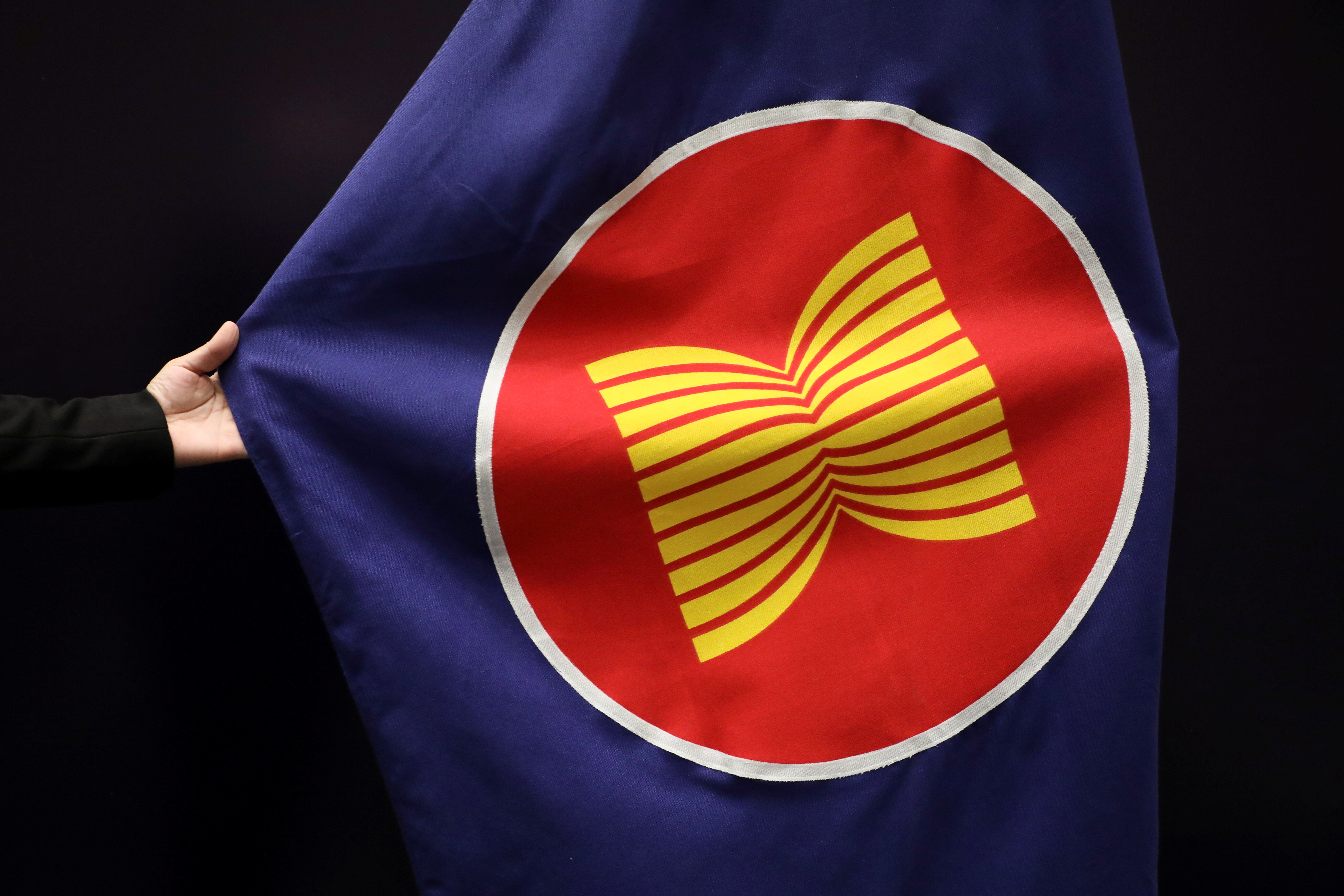 A worker adjusts an ASEAN flag at a meeting hall in Kuala Lumpur, Malaysia, October 28, 2021. ASEAN will drive future growth, with the digital economy being a major contributor.