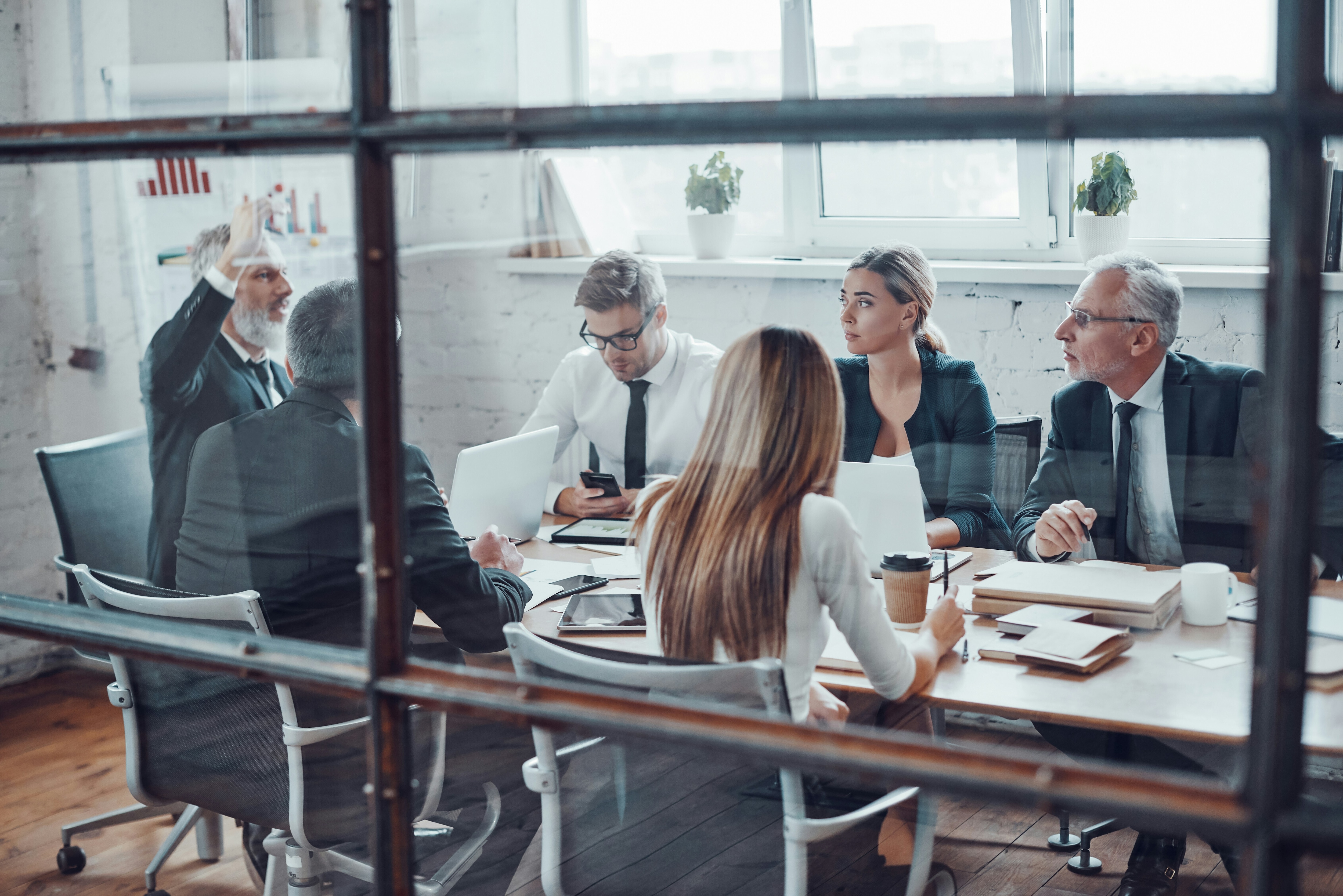 Women and men in business attire arounf a boardroom style table: Director composition has shifted within today's boards