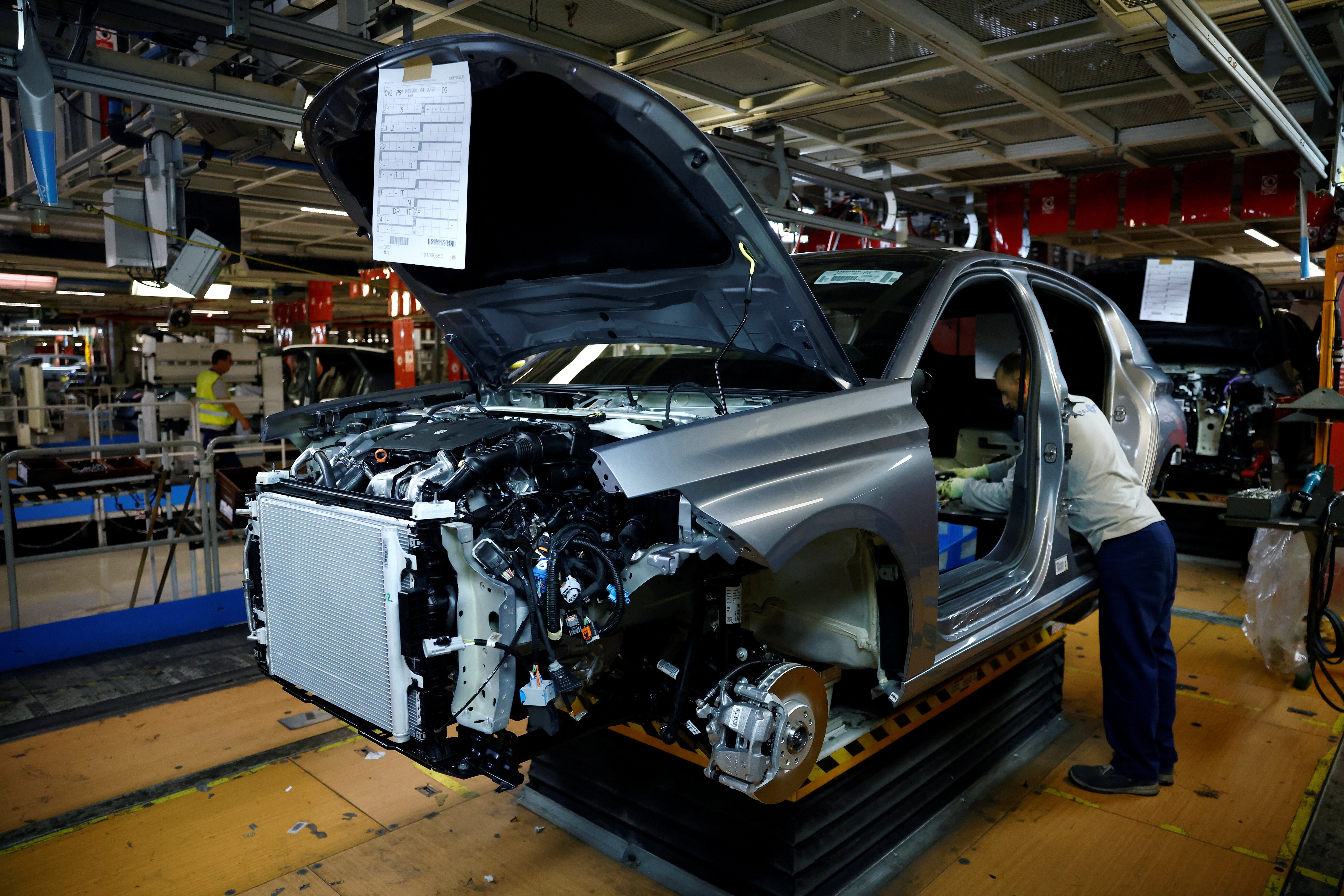 An employee works on a Peugeot 308 car being assembled on the automotive assembly line for Peugeot 308 and Peugeot 408 cars at the Stellantis factory in Mulhouse, eastern France, June 2, 2026.  REUTERS/Alice Sacco