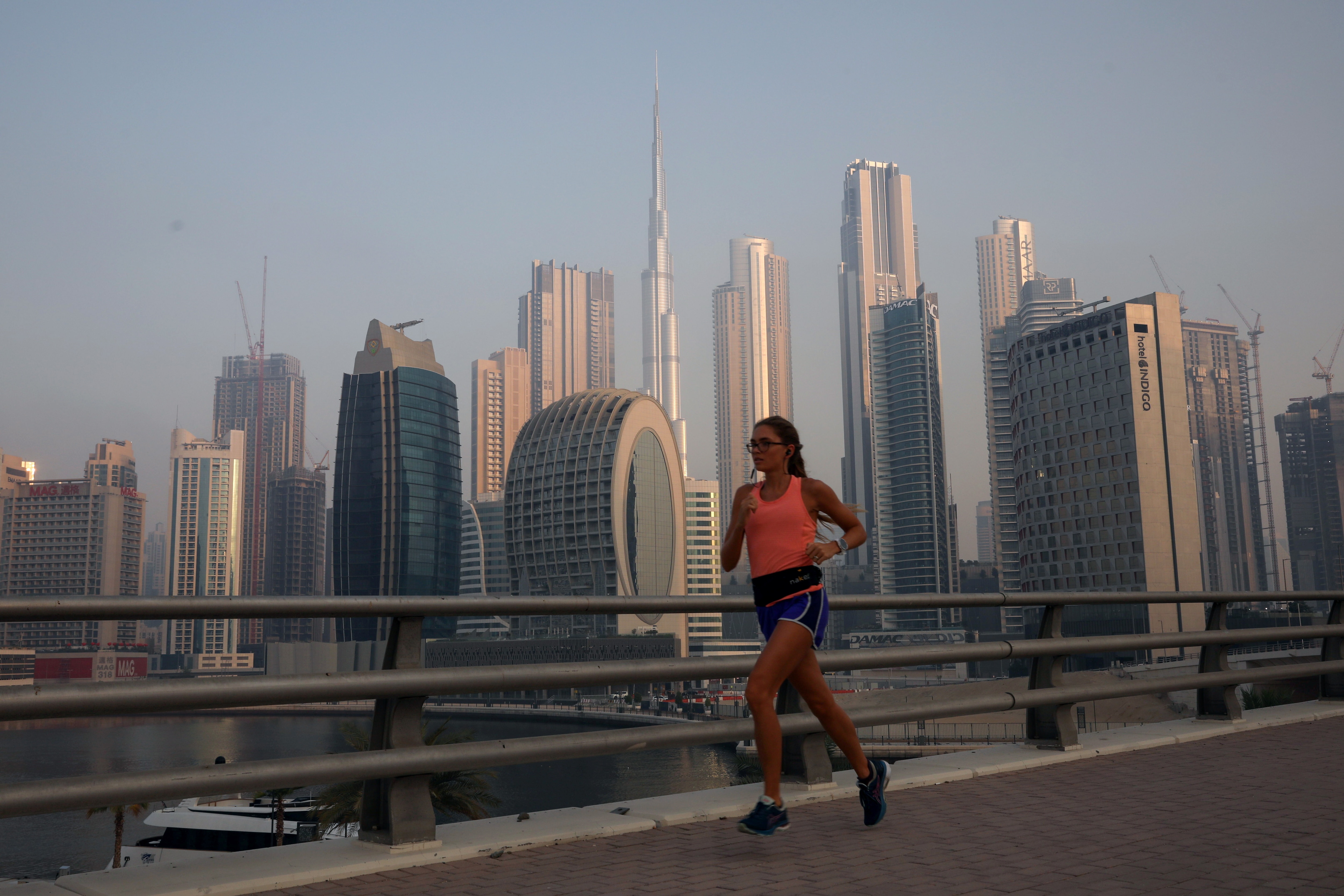 A woman runs past the Burj Khalifa and the downtown skyline in Dubai, United Arab Emirates, June 13, 2021. Agentic AI adoption is gathering pace in the GCC.