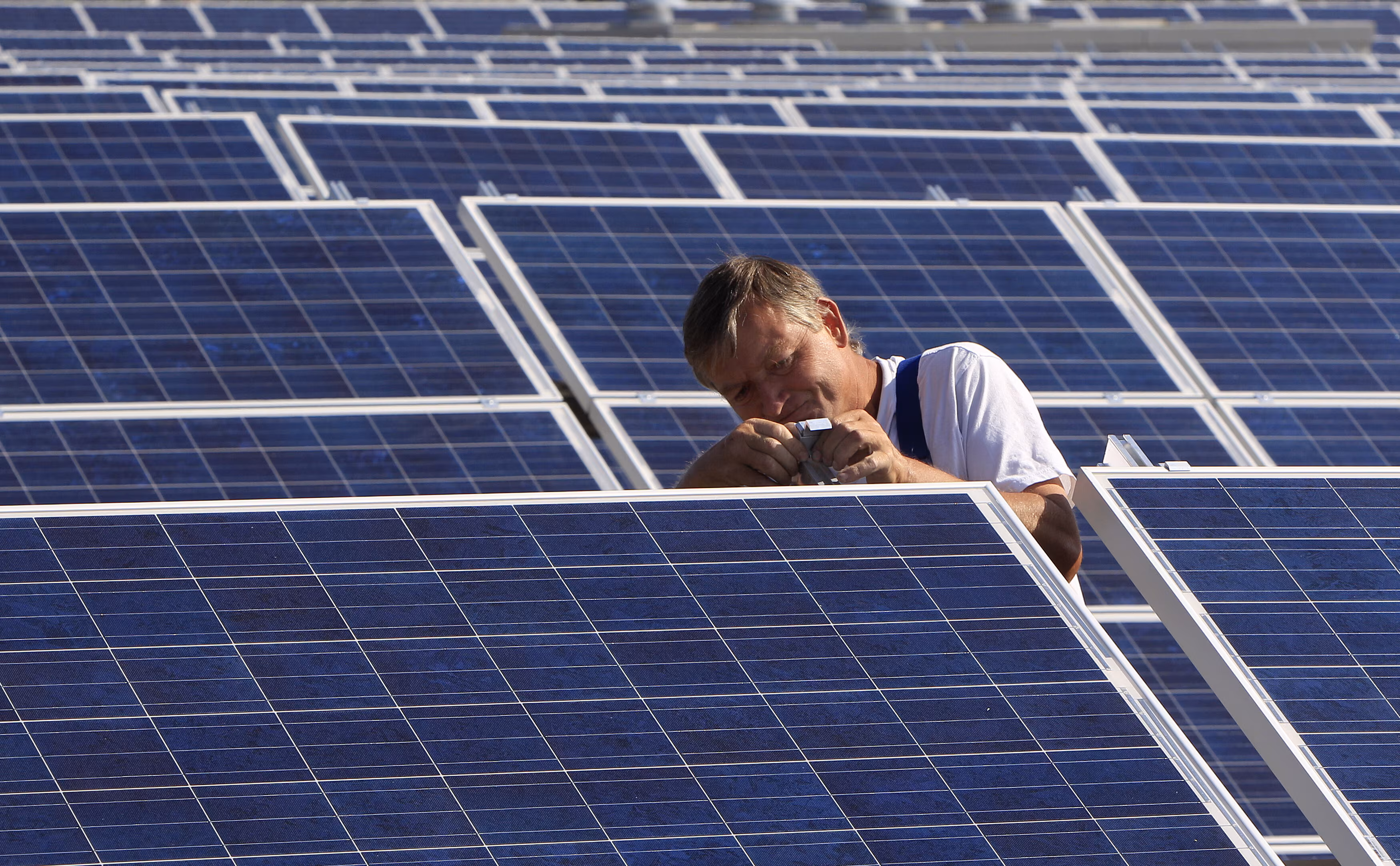 Un trabajador de la construcción instala paneles solares para una nueva planta de energía solar cerca de Olching-Esting, al oeste de Múnich.
