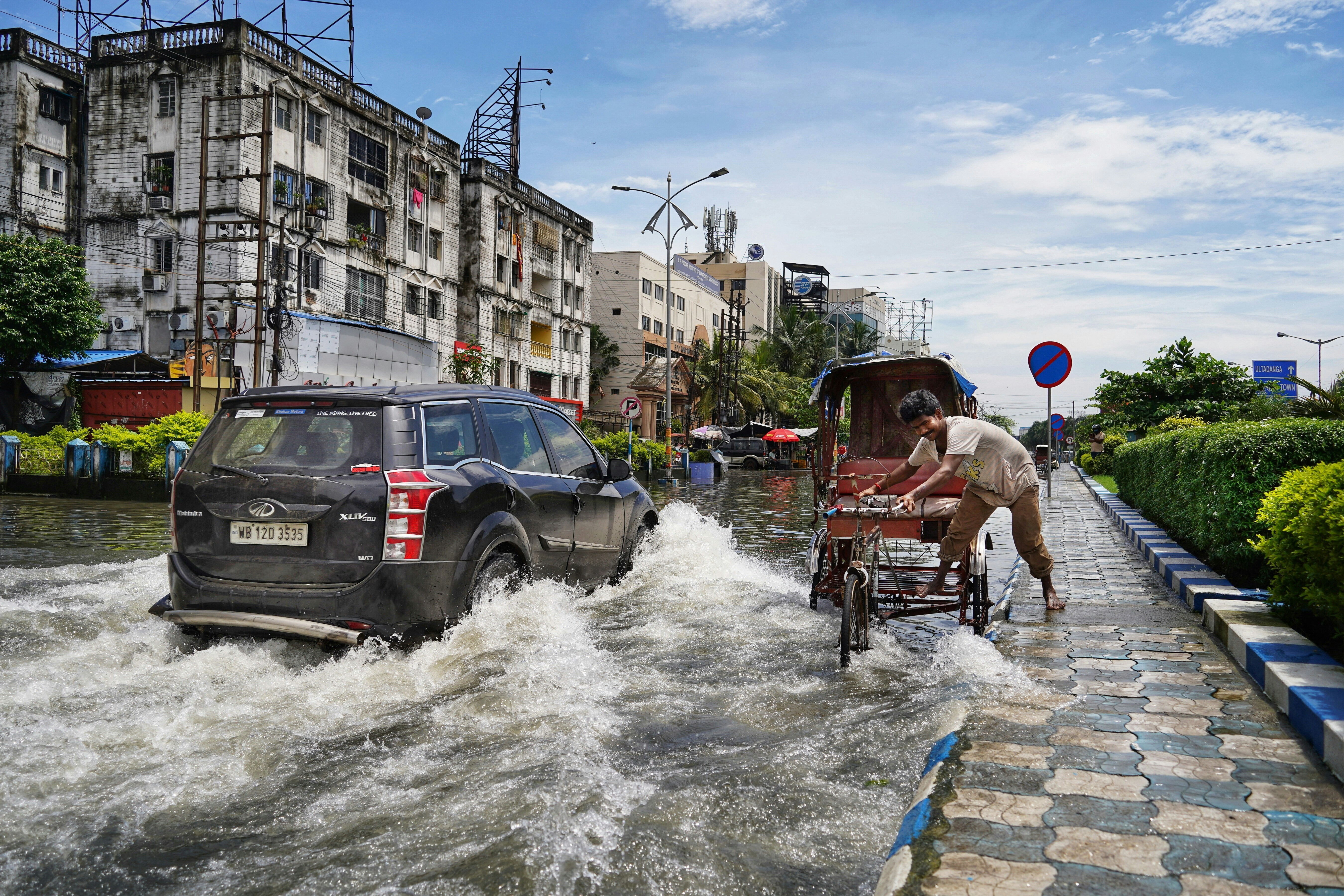 Kolkata, West Bengal, India. Vehicles and people navigate flood waters. Climate adaptation