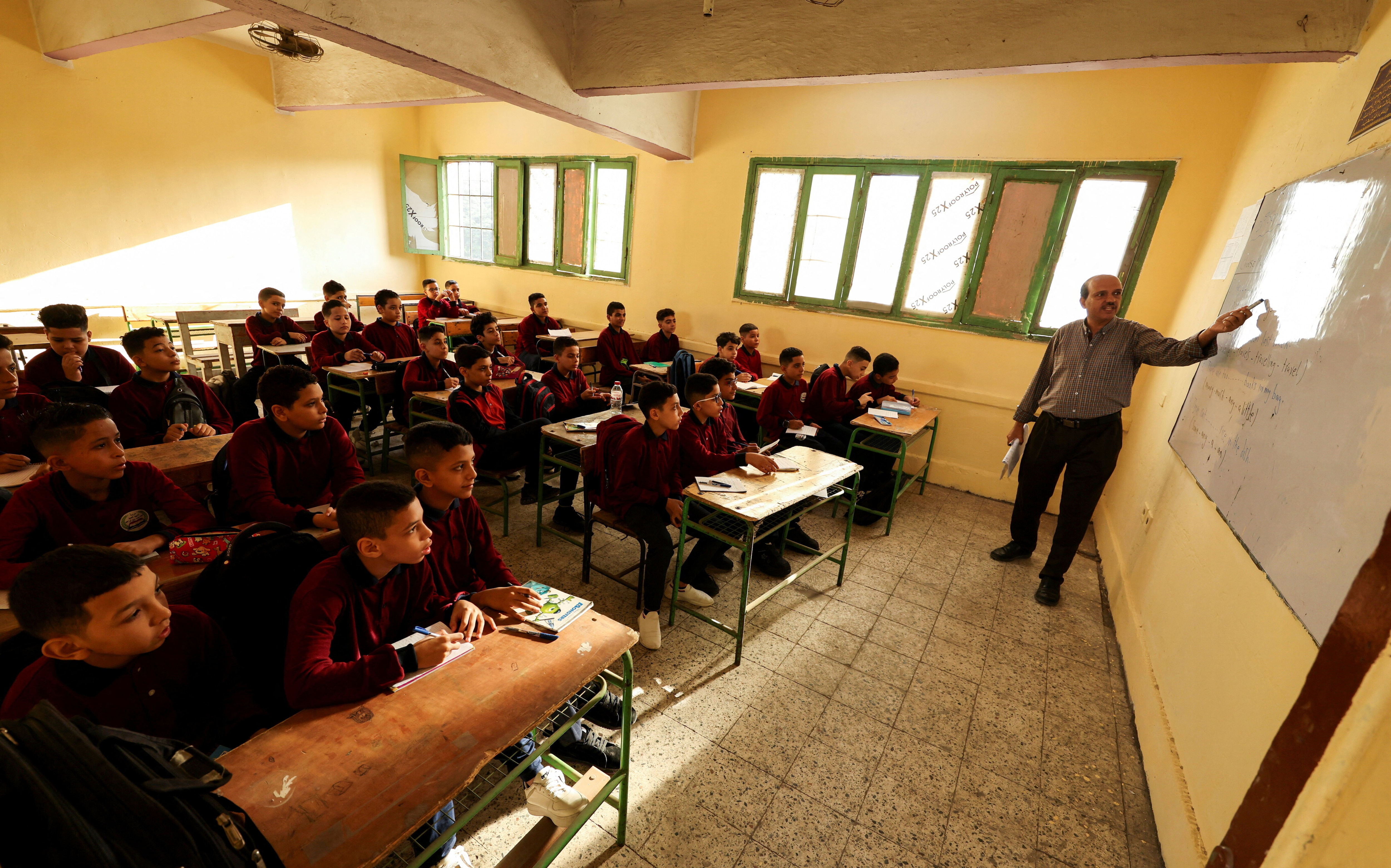 An Egyptian teacher instructs students on the first day of the academic year at Giza Preparatory School for Boys in 2025. 