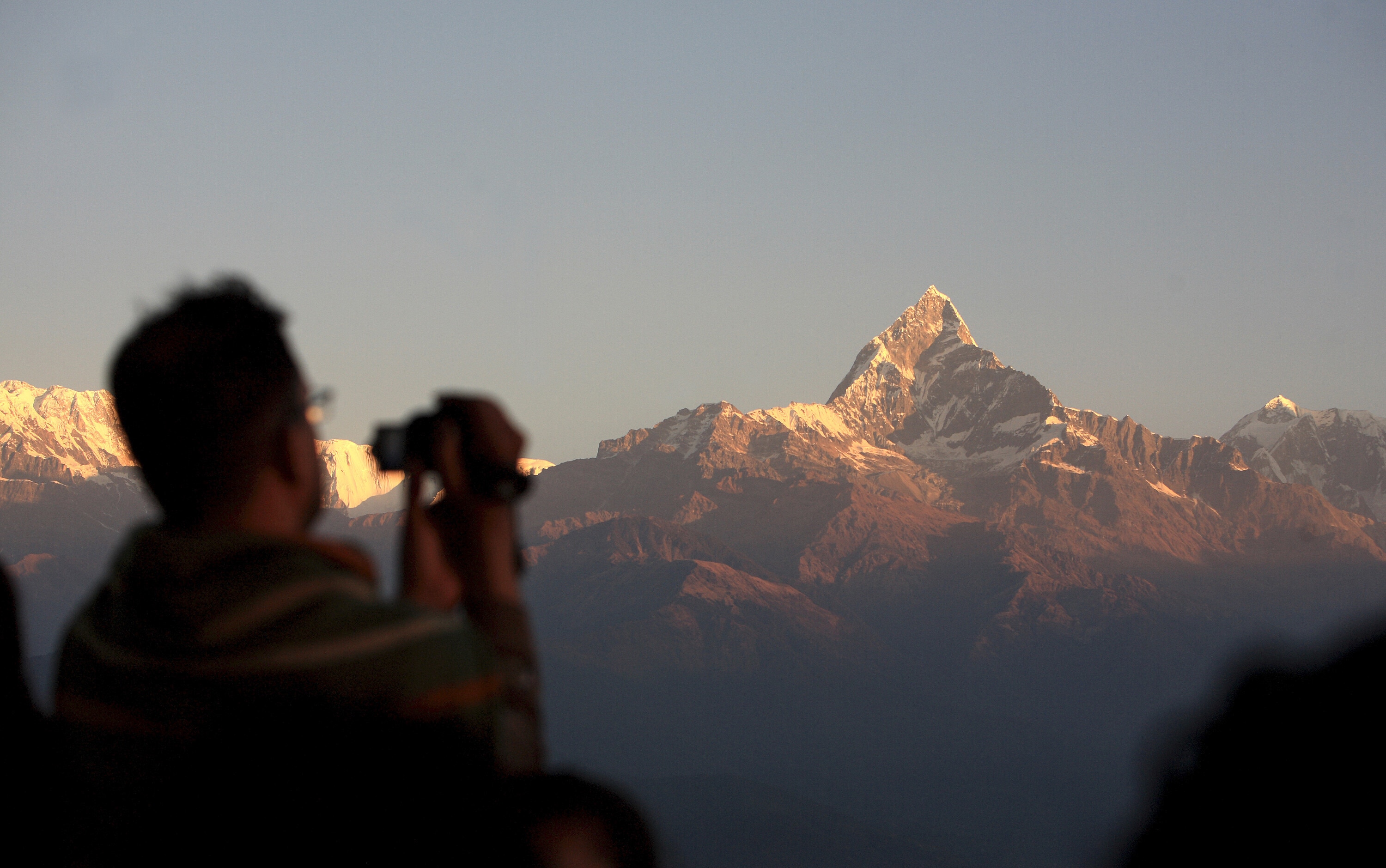 Tourists view the snow-capped Mount Annapurna range (8,091m) from Sarangkot, Pokhara, Nepal.
