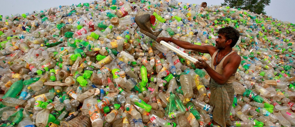 A man makes a heap of plastic bottles at a junkyard on World Environment Day in Chandigarh, India, June 5, 2018. REUTERS/Ajay Verma - RC1DE0385630