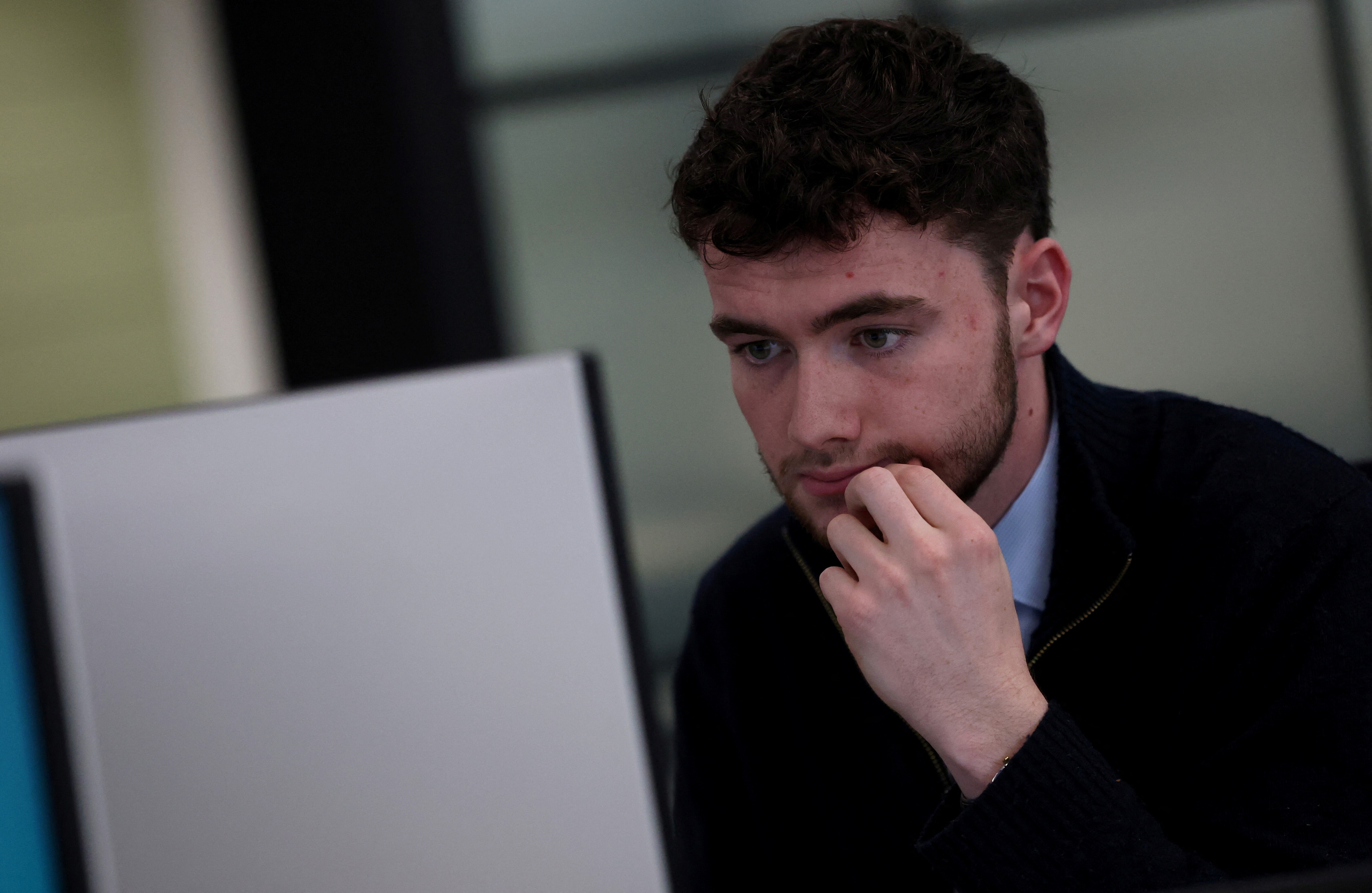 An employee works on his computer at the Moore Kingston Smith office in London, Britain, November 13, 2025. REUTERS/Hannah McKay