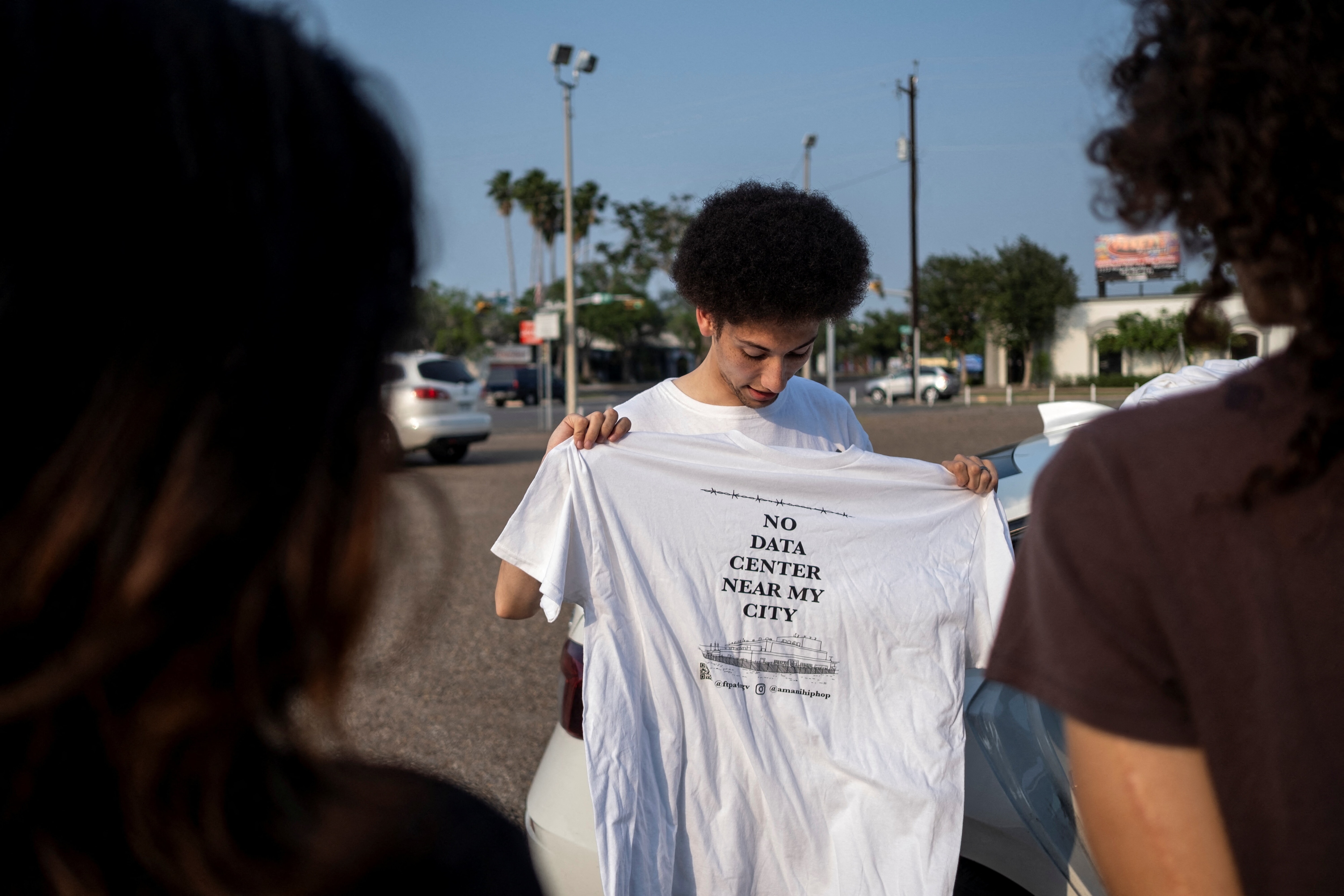 Isaac Amani Newman shows supporters a shirt he made protesting the data center being proposed by a subsidiary of Eneus Energy following a Harlingen City Commission meeting in Harlingen, Texas, U.S. May 6, 2026. REUTERS/Joel Angel Juarez