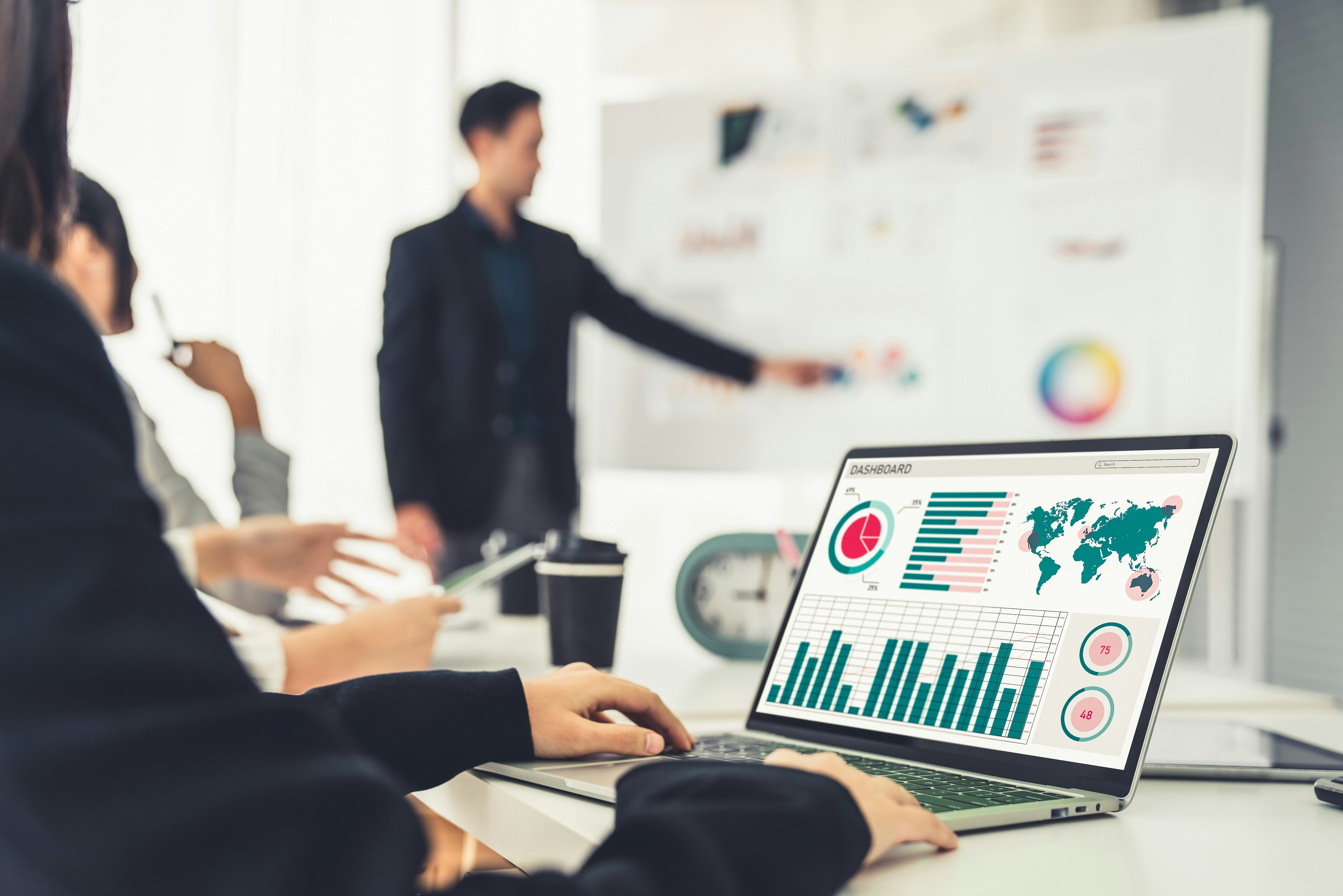 An office worker looks at a laptop screen with data filled dansboard: Connected data can help improve performance