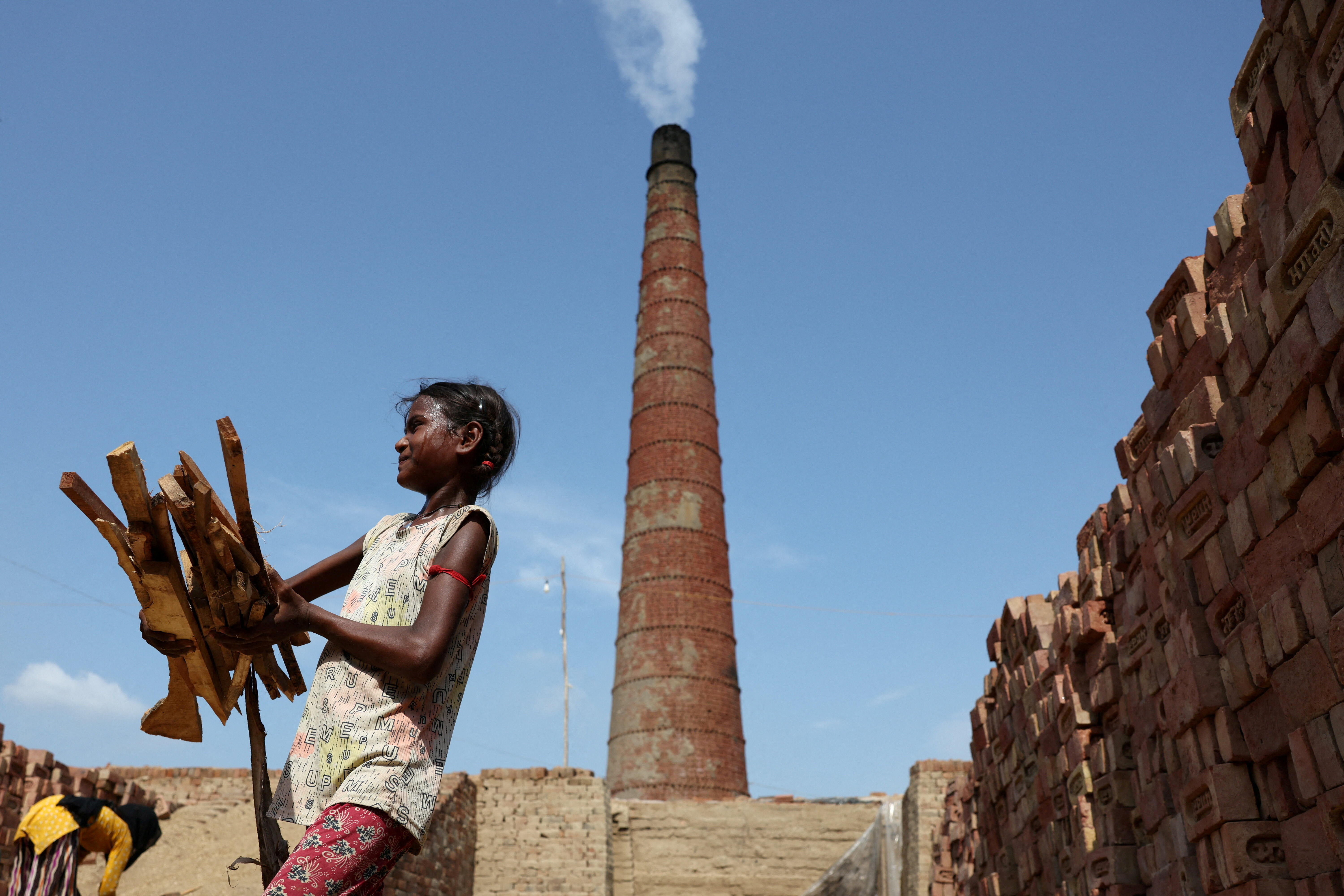 A girl picks up wood to fire a brick kiln, in Mathura, India June 19, 2025: Black carbon mitigation offers a triple win